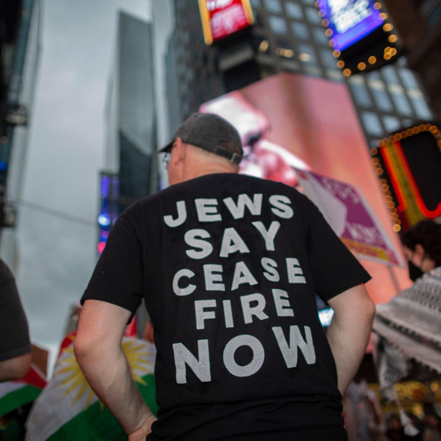 A demonstrator wearing a t-shirt with Jews Says Cease Fire