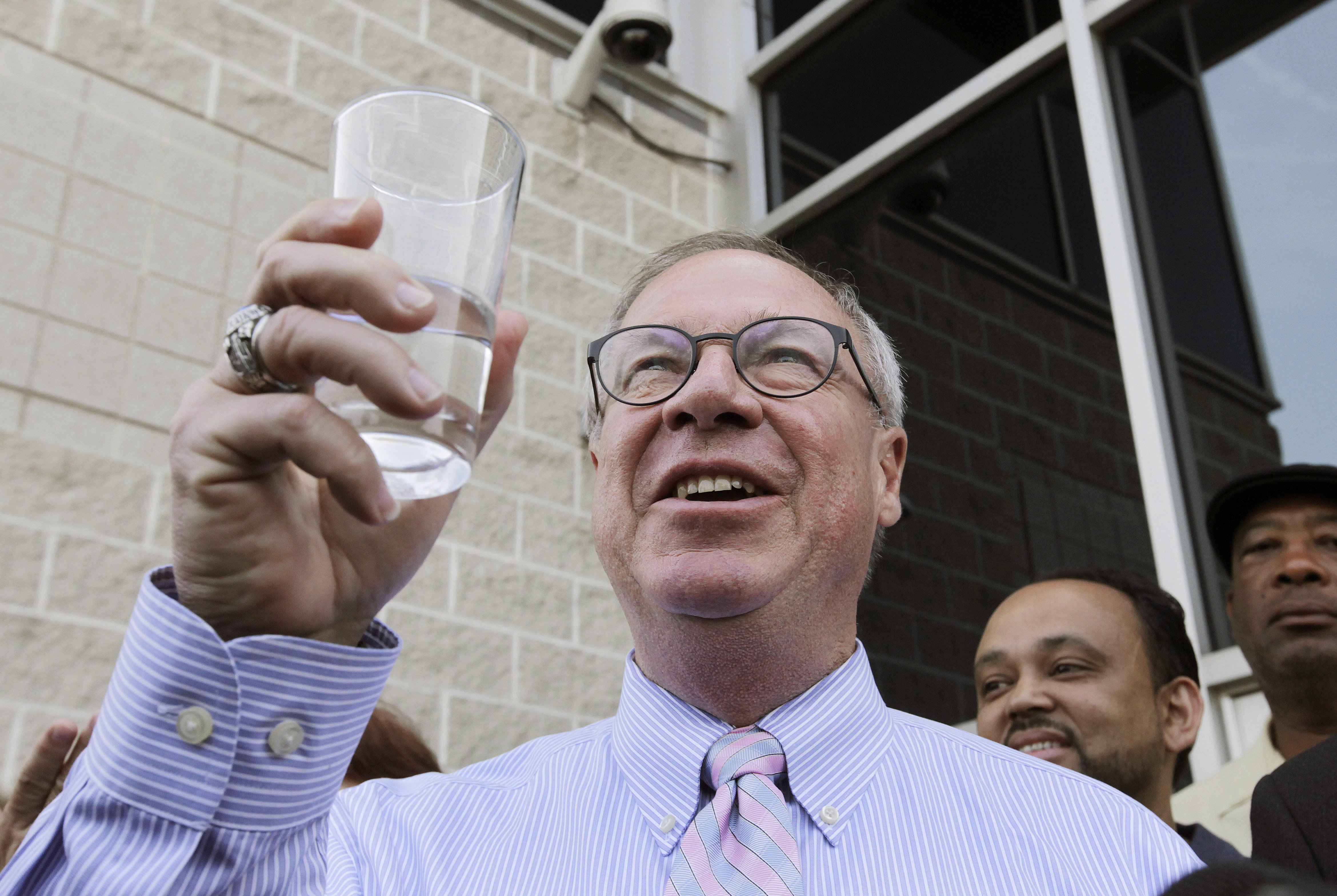 Toledo Mayor D. Michael Collins raises a glass of tap water before drinking it during a news conference in Toledo, Ohio on Aug. 4, 2014.