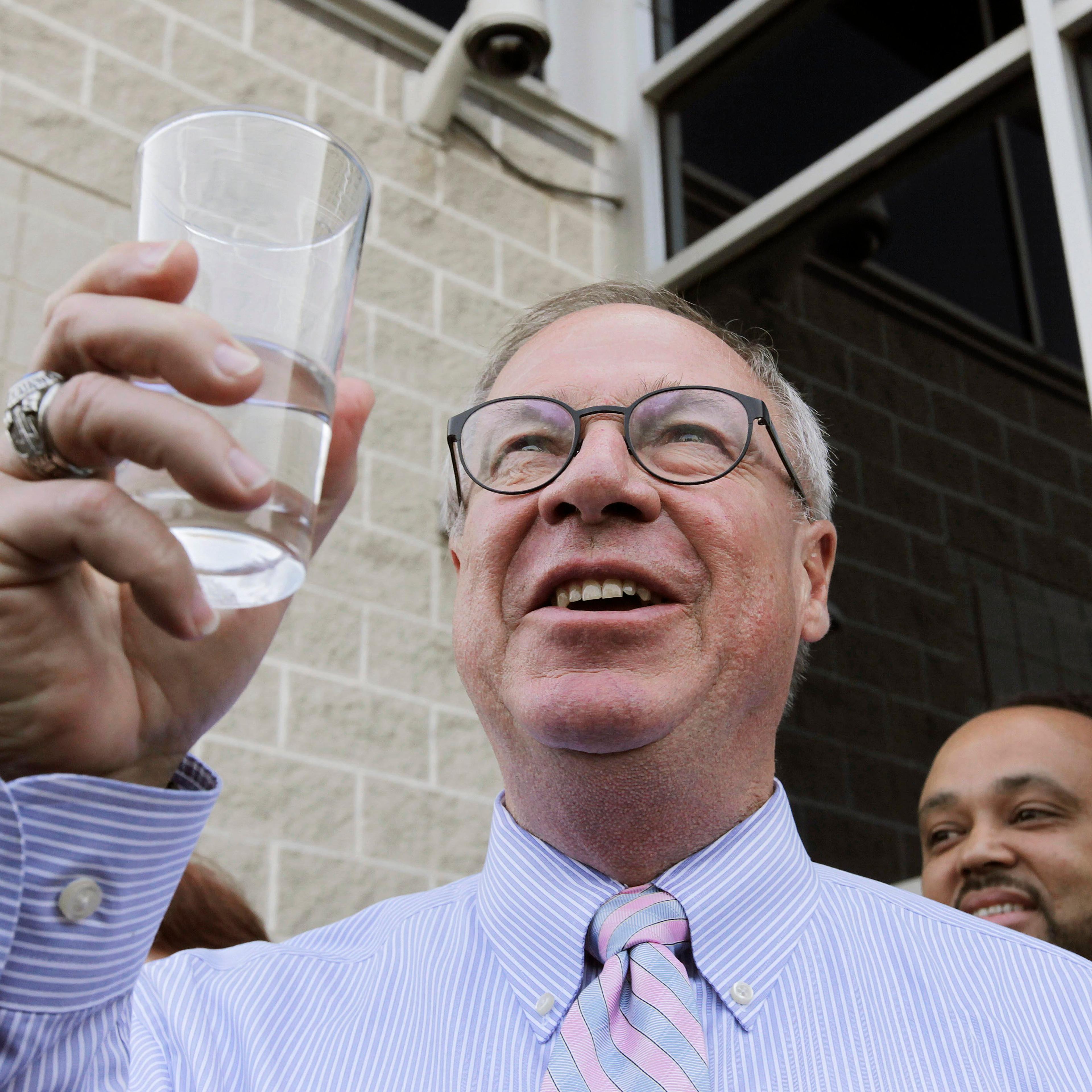 Toledo Mayor D. Michael Collins raises a glass of tap water before drinking it during a news conference in Toledo, Ohio on Aug. 4, 2014.