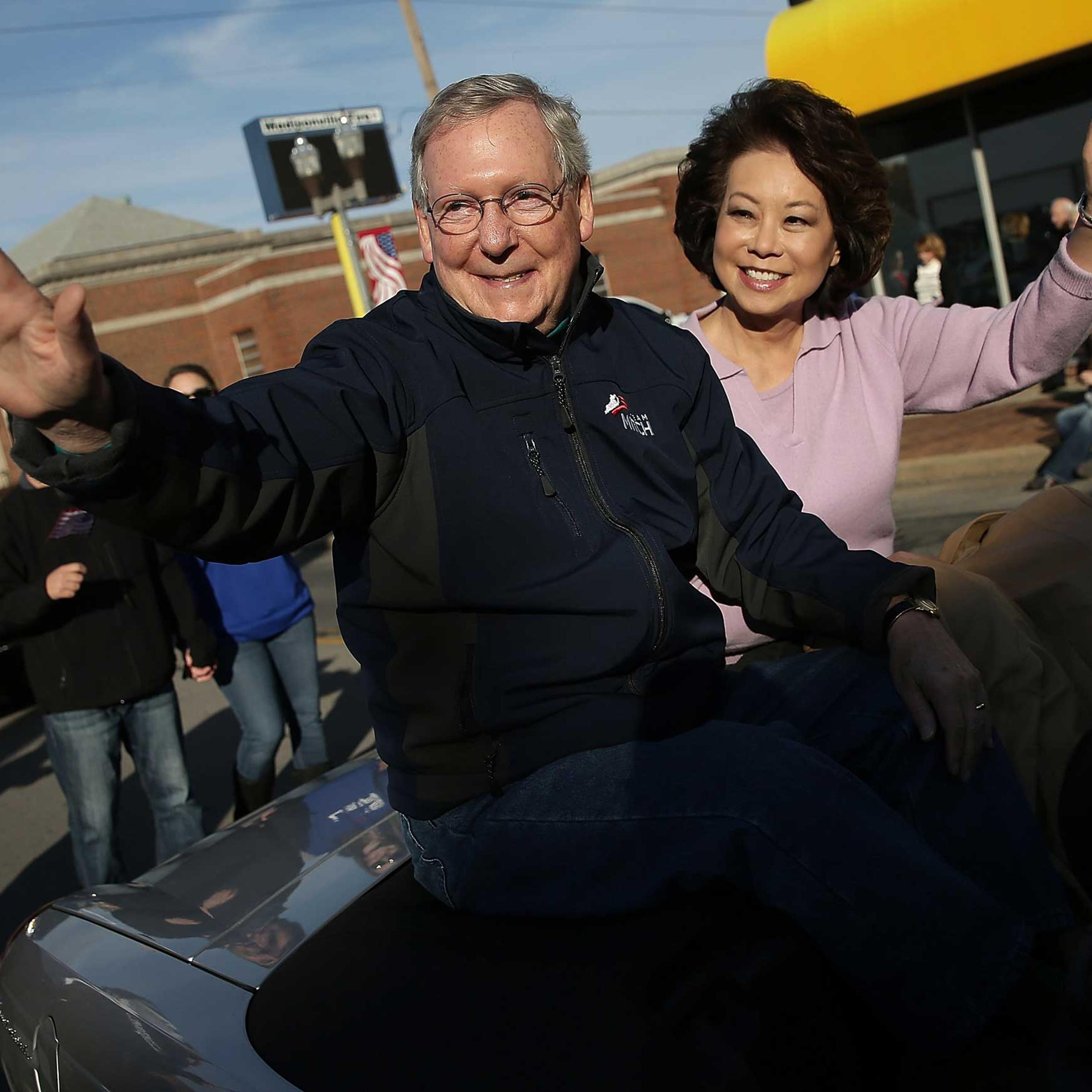 Senate Minority Leader Mitch McConnell (R-KY) waves while riding with his wife Elaine Chao (R) in the Hopkins Country Veterans Day Parade on November 2, 2014 in Madisonville, Ky.