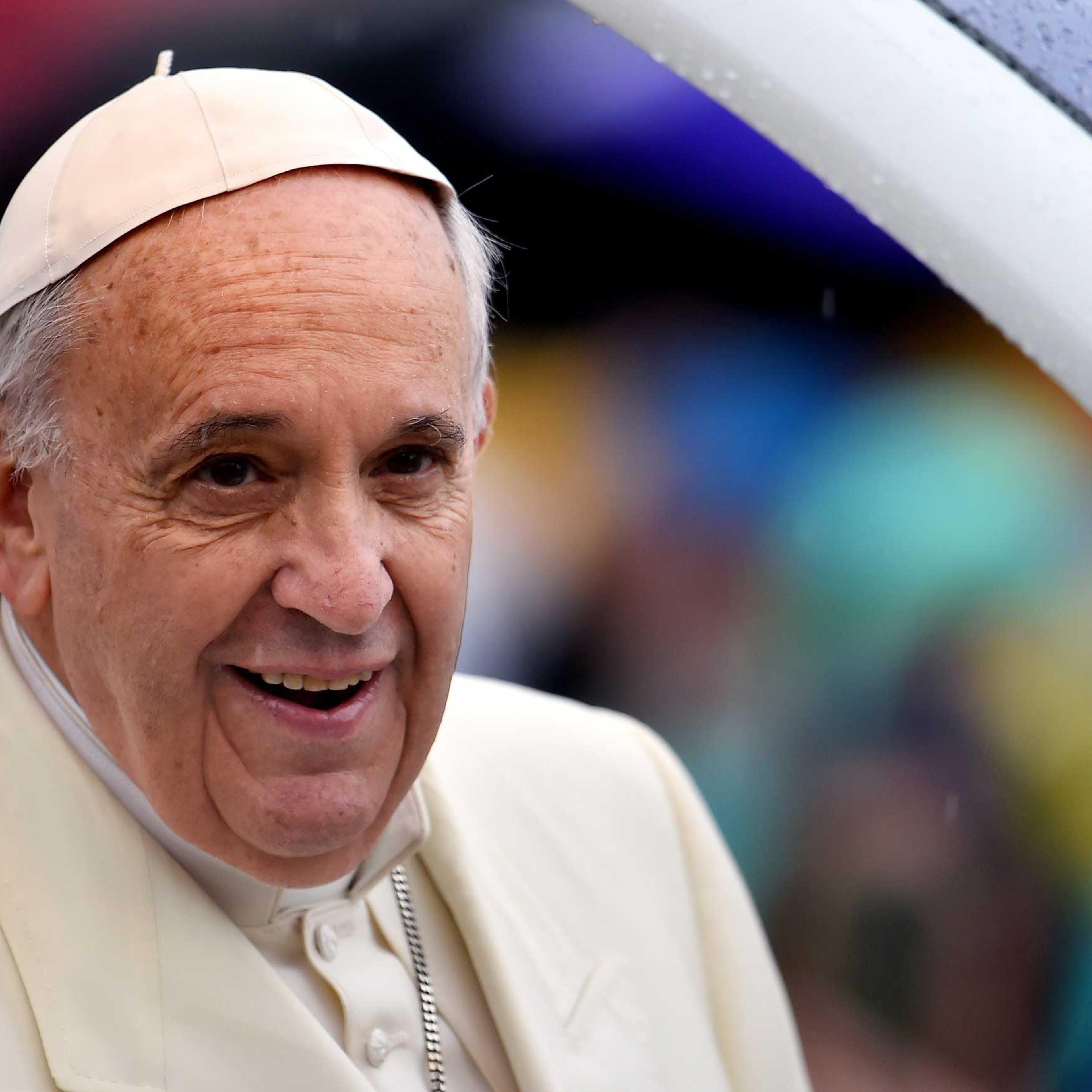 Pope Francis arrives under heavy rain, for his weekly general audience in St Peter's square at the Vatican on March 25, 2015.