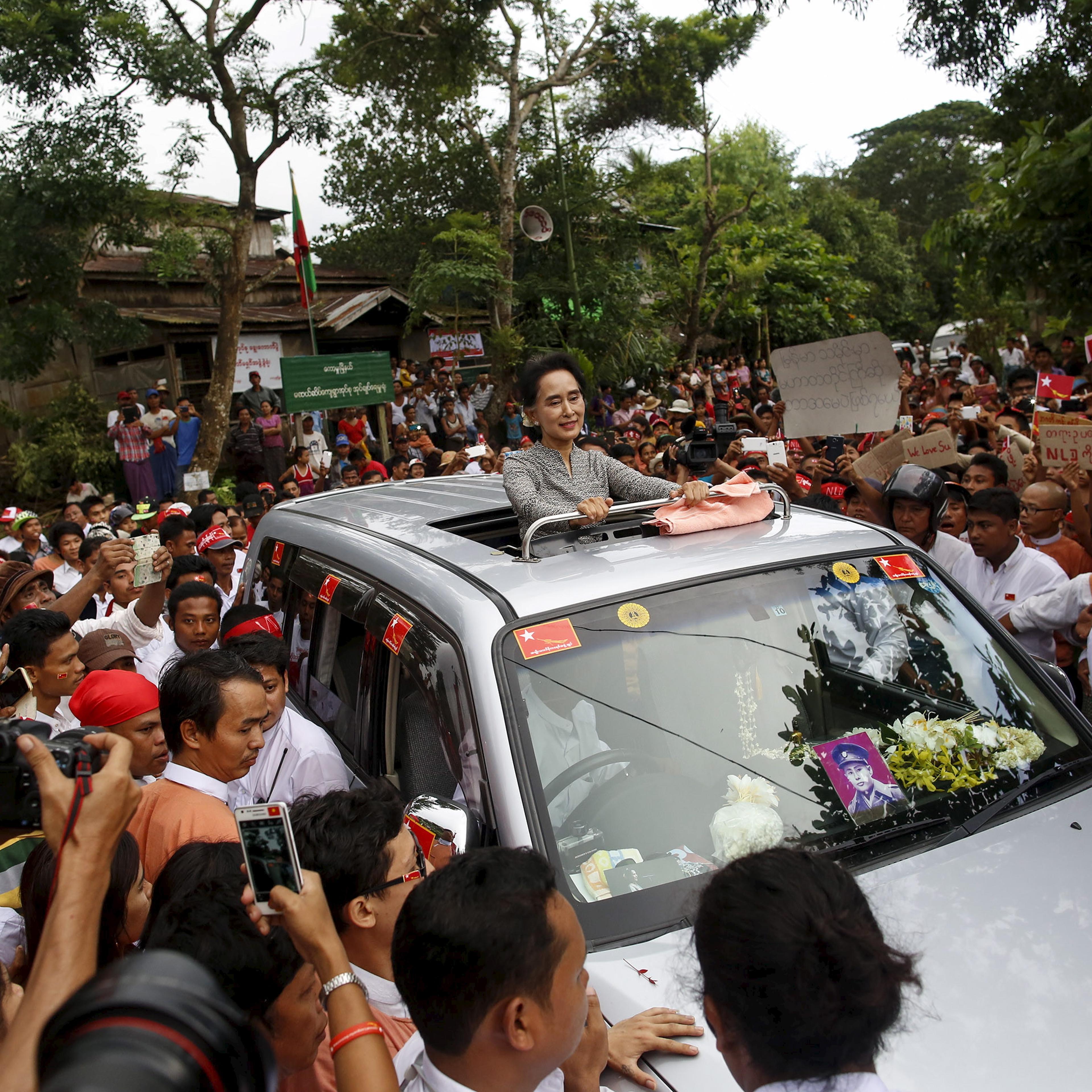 Myanmar pro-democracy leader Aung San Suu Ky smiles as she greets her supporters during her campaign in her constituency of Kawhmu township outside Yangon