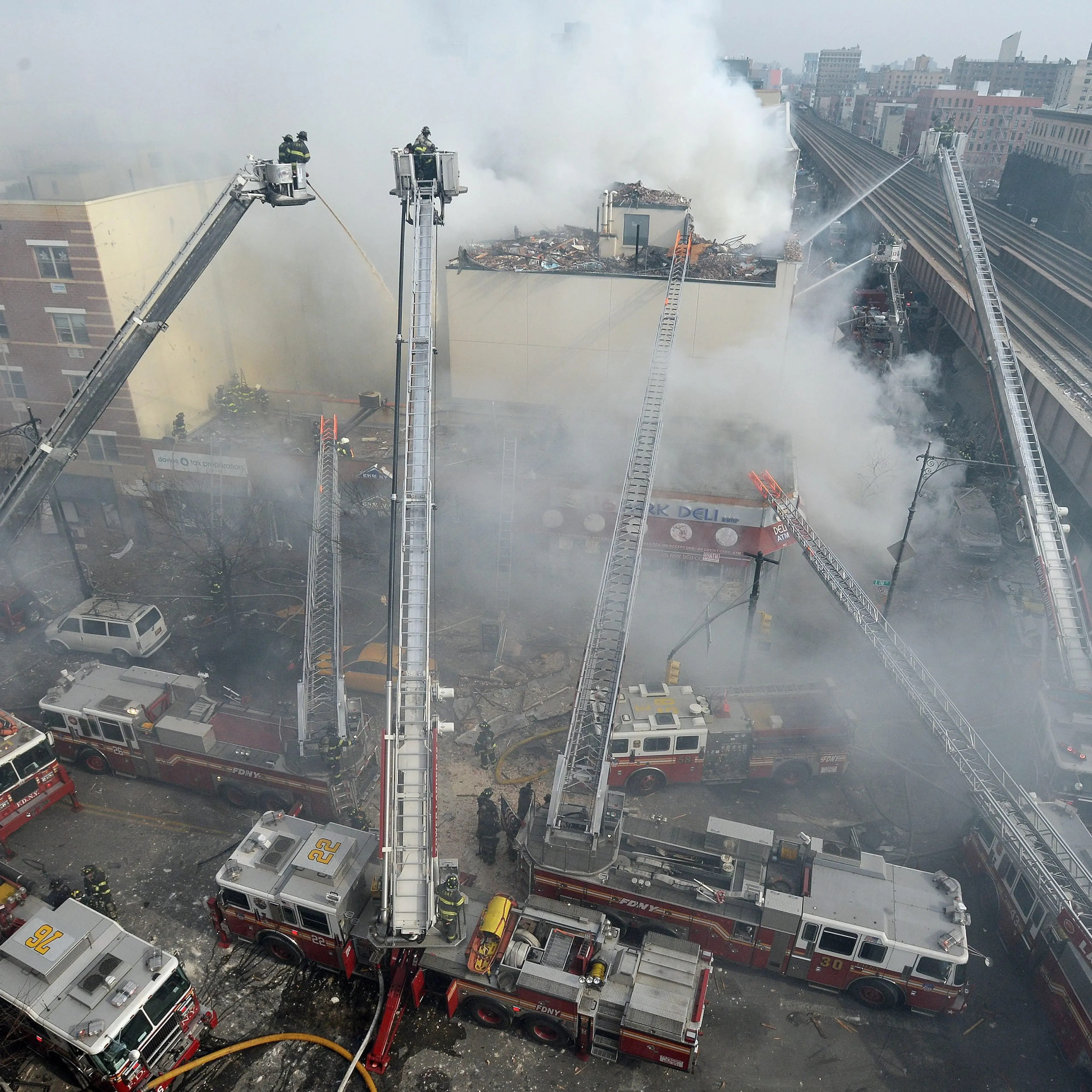 Firefighters extinguish a fire after a reported explosion and building collapse