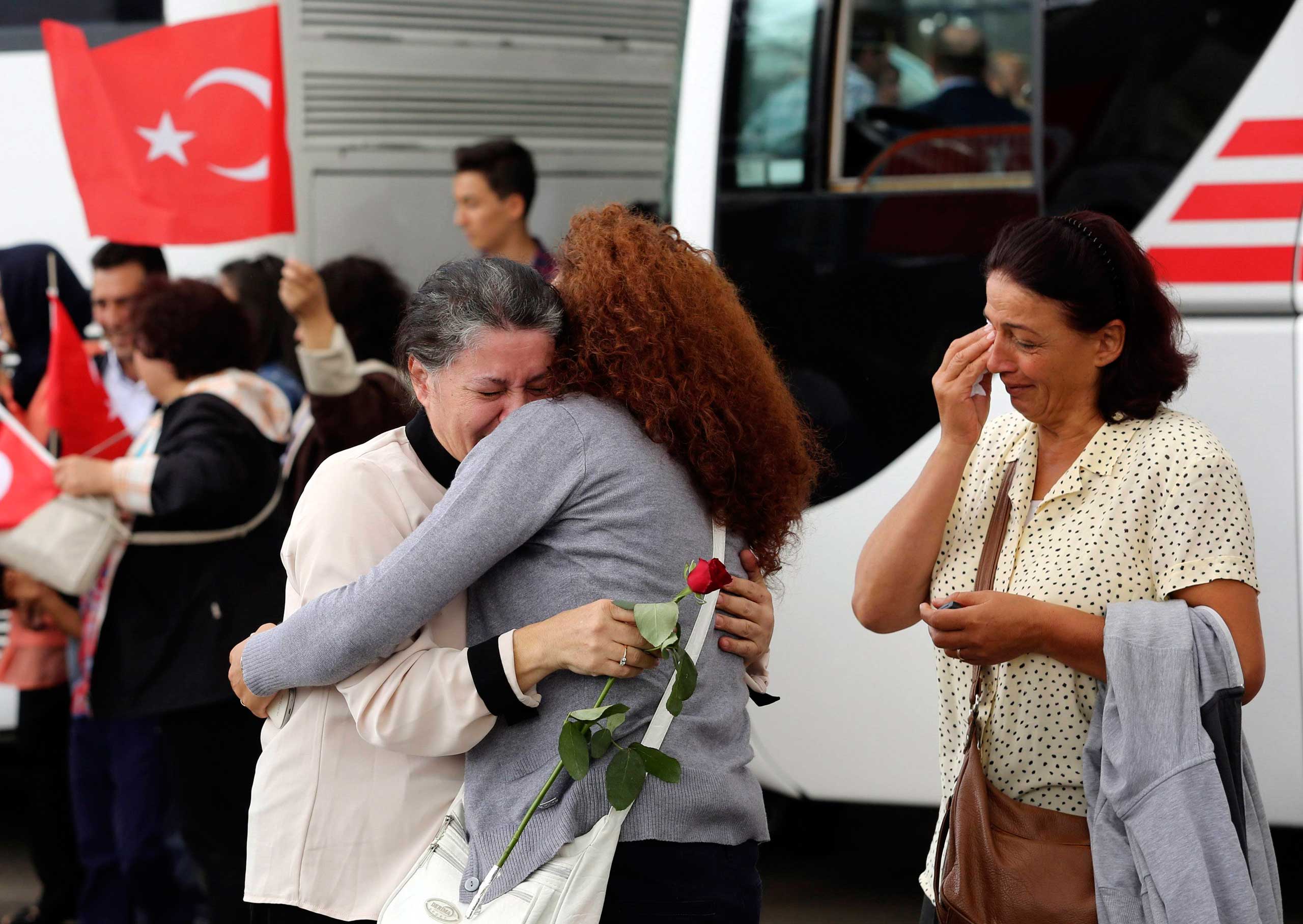 Employee at Turkey's consulate in Mosul is welcomed by her relatives at Esenboga airport in Ankara