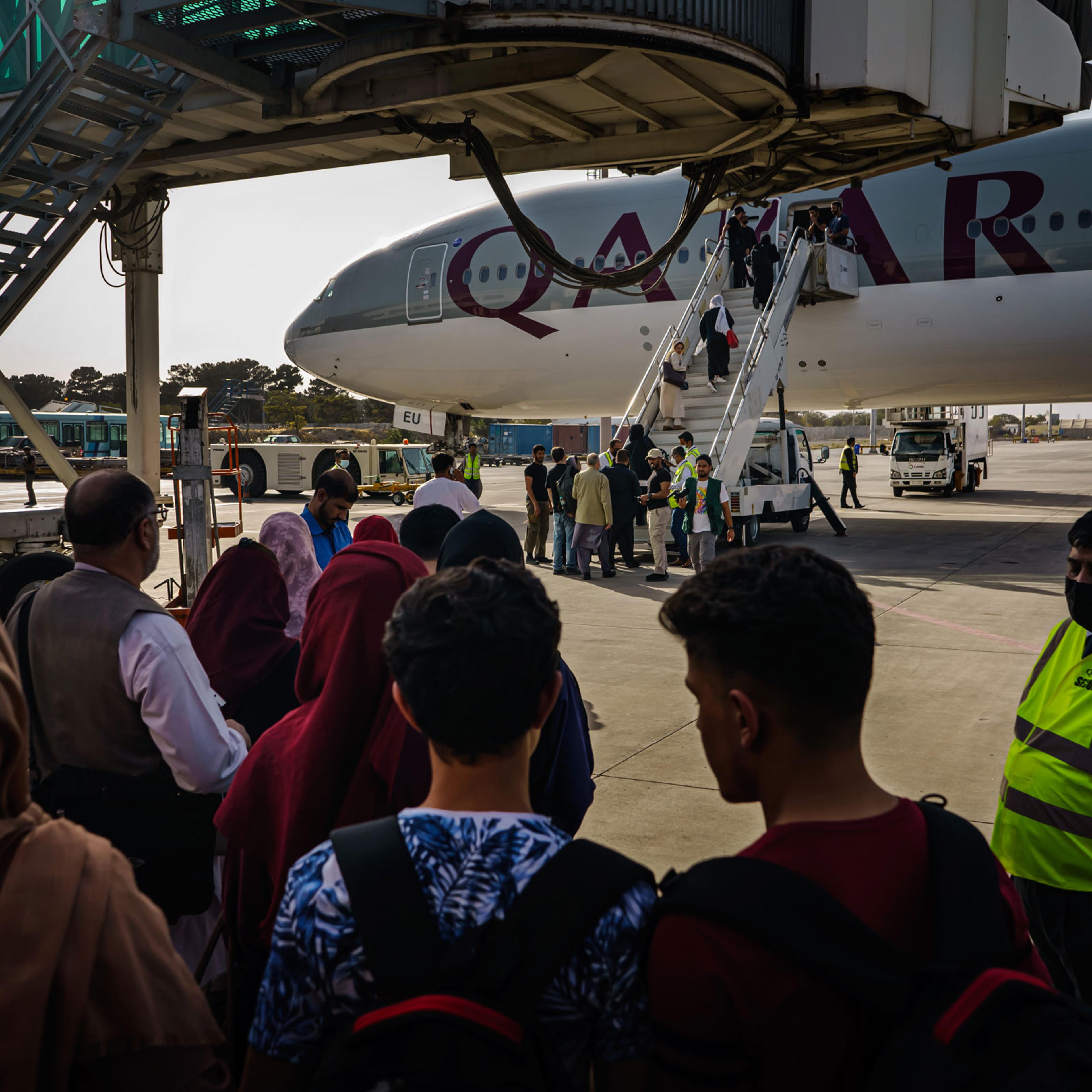 People prepare to board an evacuation flight out of Kabul in October 2021