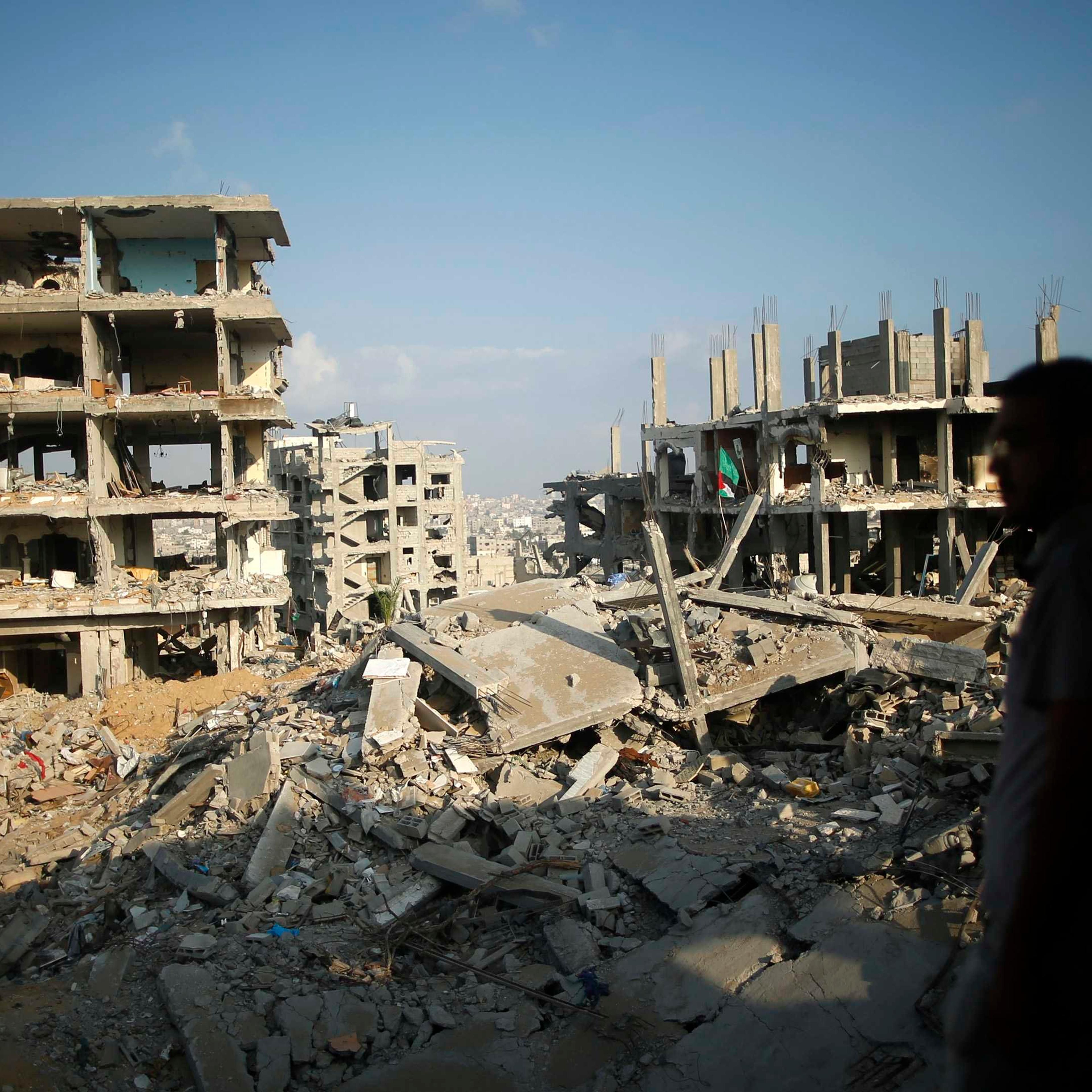 A Palestinian man stands atop the rubble of his house as he looks at the ruins of his neighborhood that was badly damaged during the 50-day war between the Hamas militant movement and Israel, in the east of Gaza City on Oct. 12, 2014.