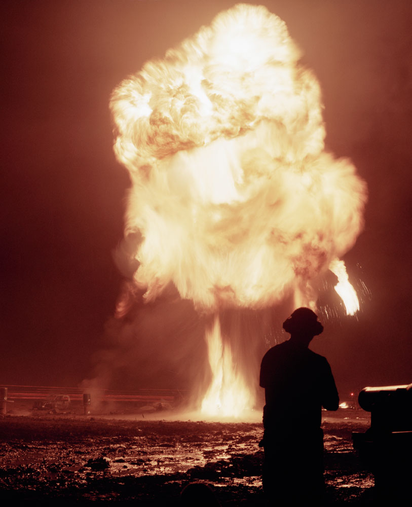 A participant stands in front of a towering fireball.