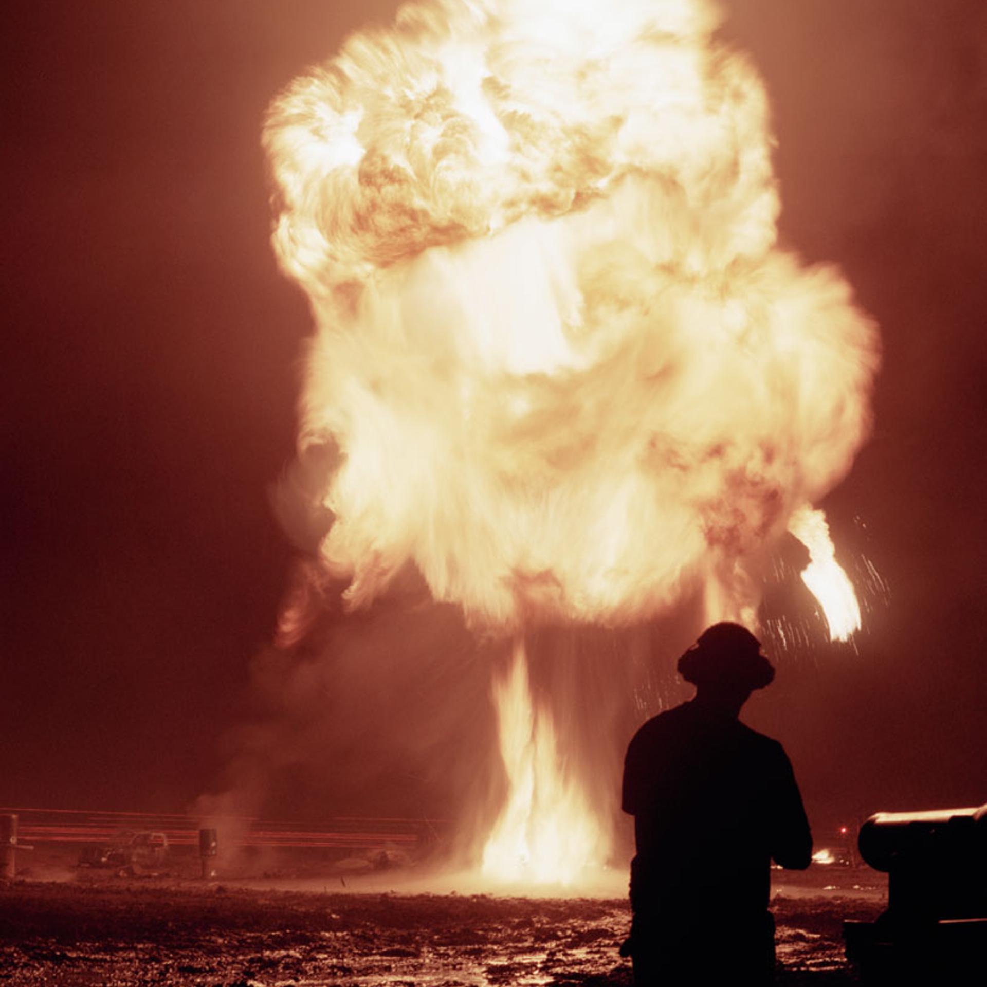 A participant stands in front of a towering fireball.