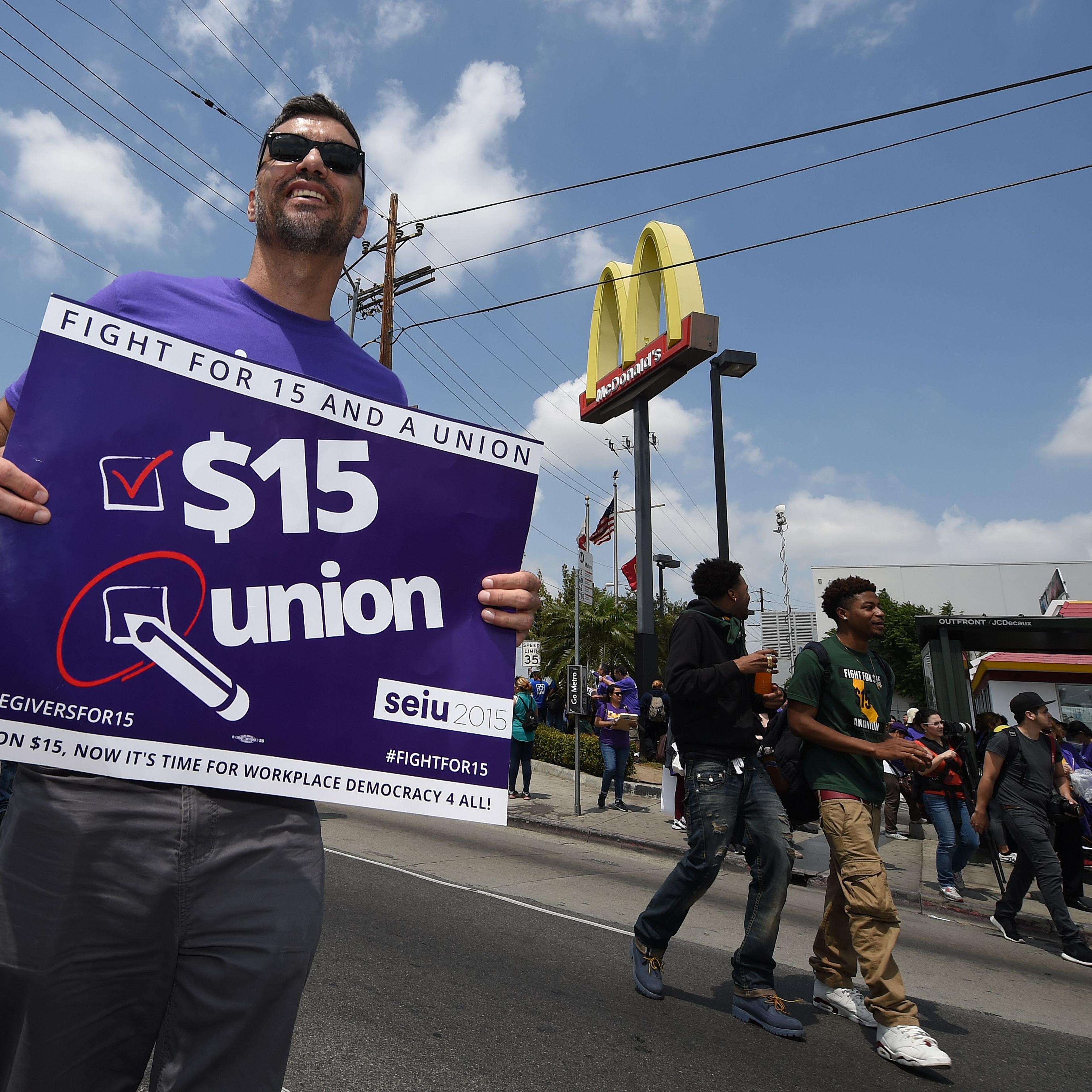Workers from the fast-food, home care and child care industries protest outside a McDonald's restaurant as they demand a nationwide $15-an-hour minimum wage, in Los Angeles, California on April 14, 2016.