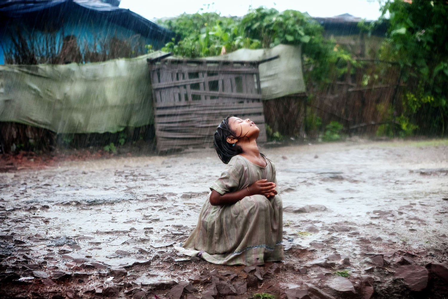 A girl turns her face to the rain in Bhopal, India.