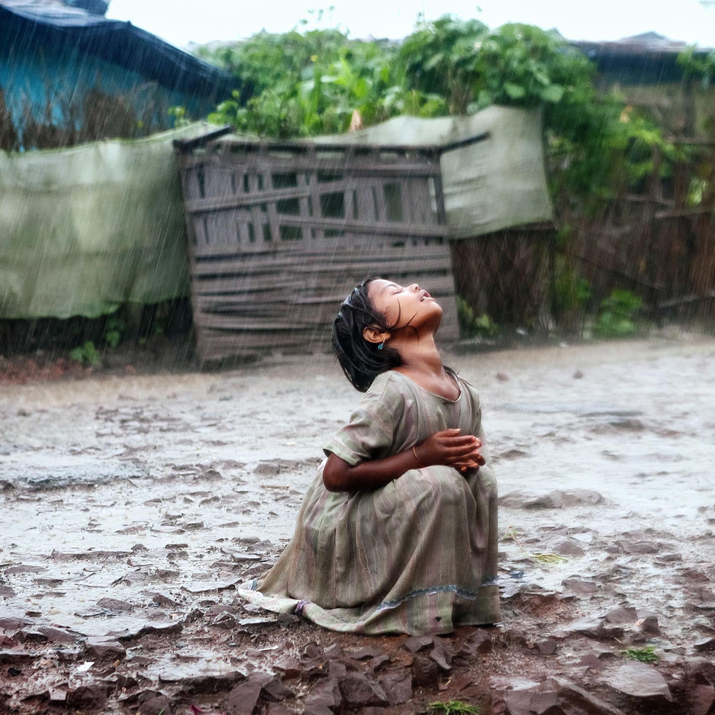 A girl turns her face to the rain in Bhopal, India.