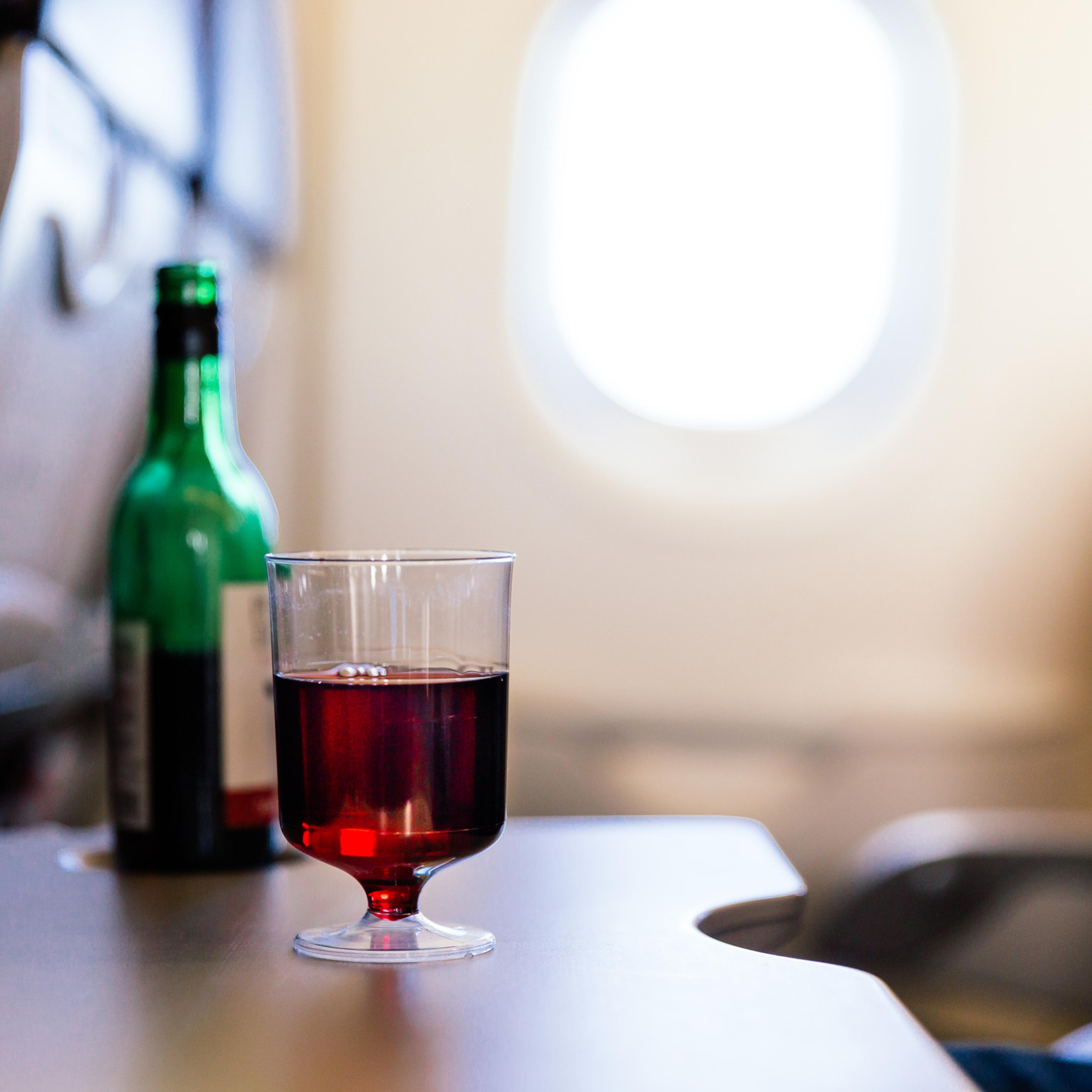 Plastic cup of red wine in the airplane