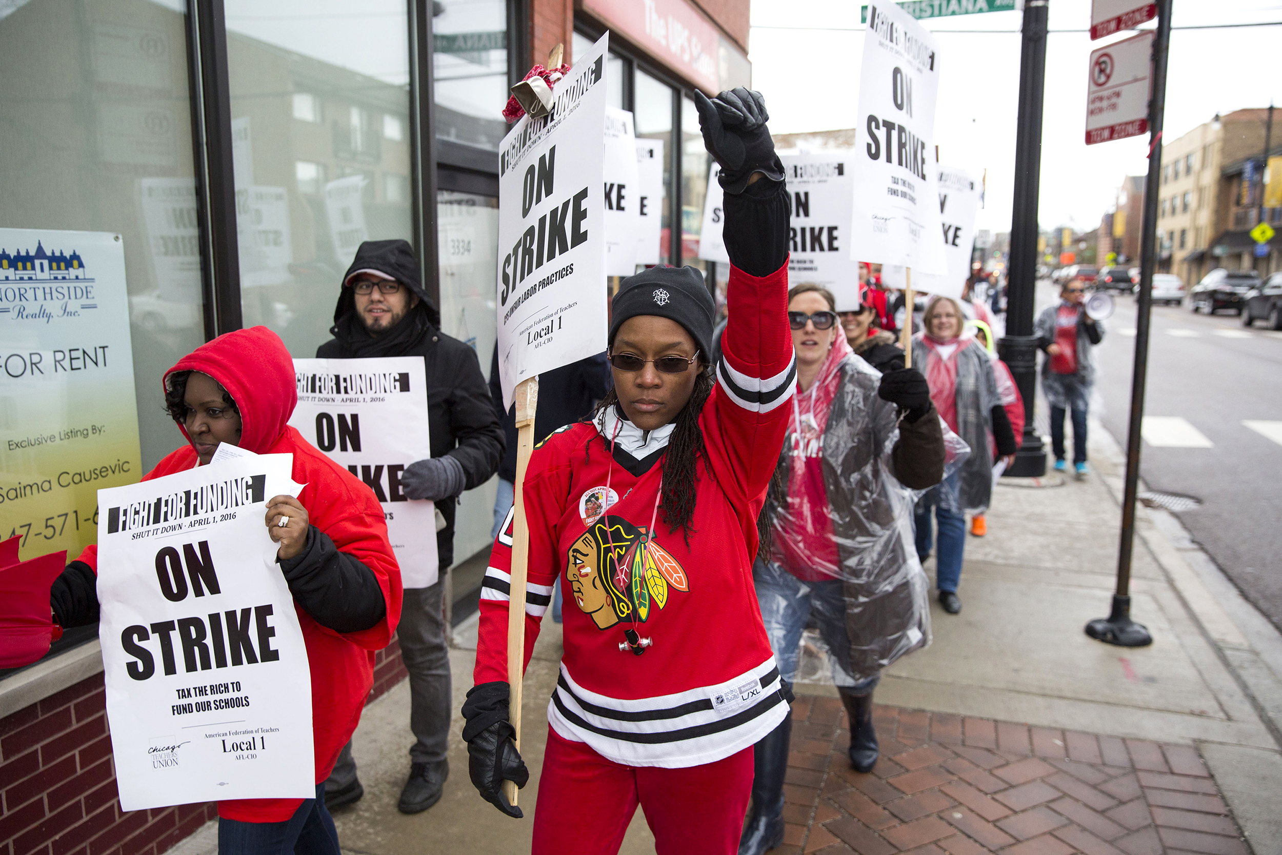 Chicago Teachers Union member Karoline Towner holds her fist in the air while marching to Northeastern Illinois University from Roosevelt High School during a one-day strike in Chicago on April 1, 2016.