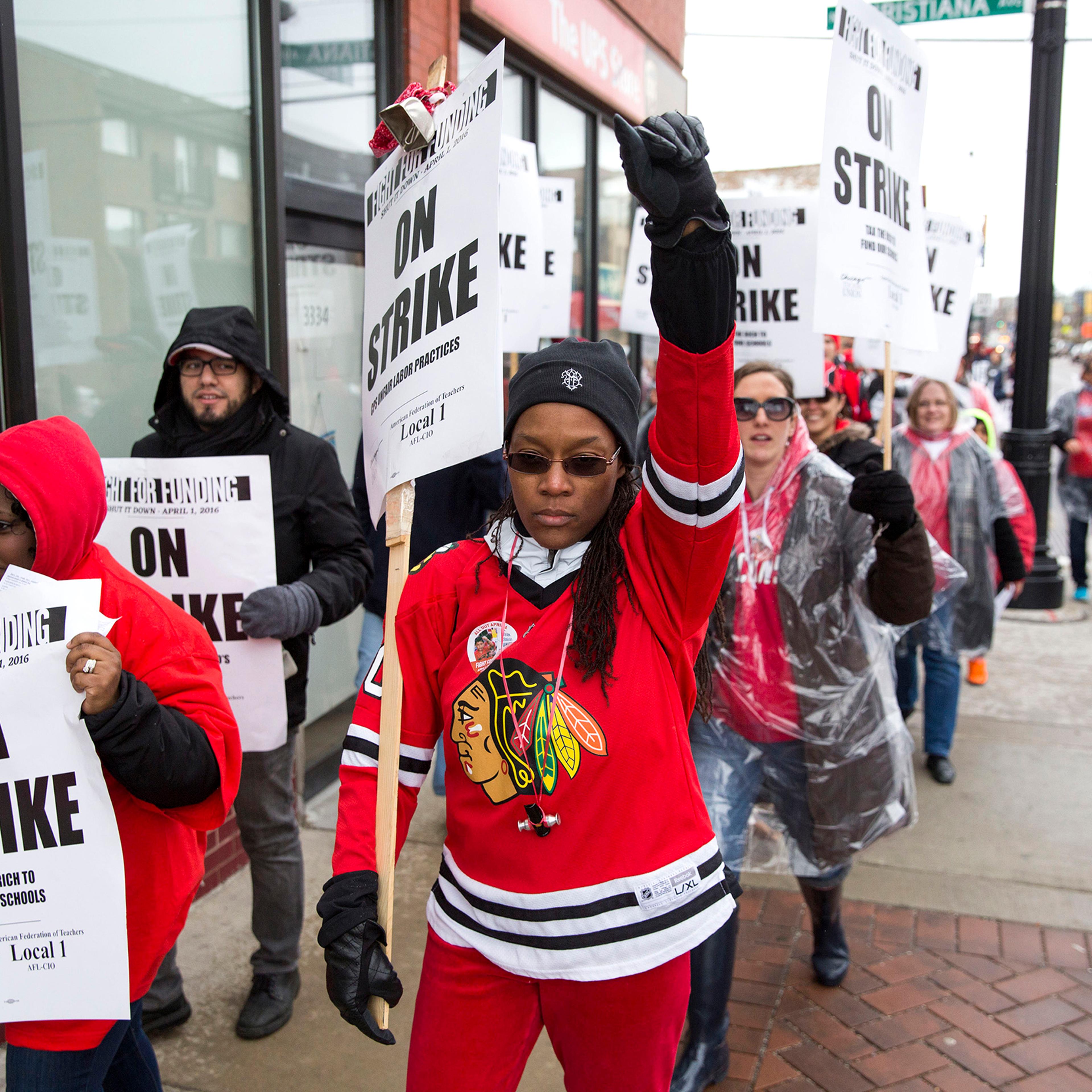 Chicago Teachers Union member Karoline Towner holds her fist in the air while marching to Northeastern Illinois University from Roosevelt High School during a one-day strike in Chicago on April 1, 2016.