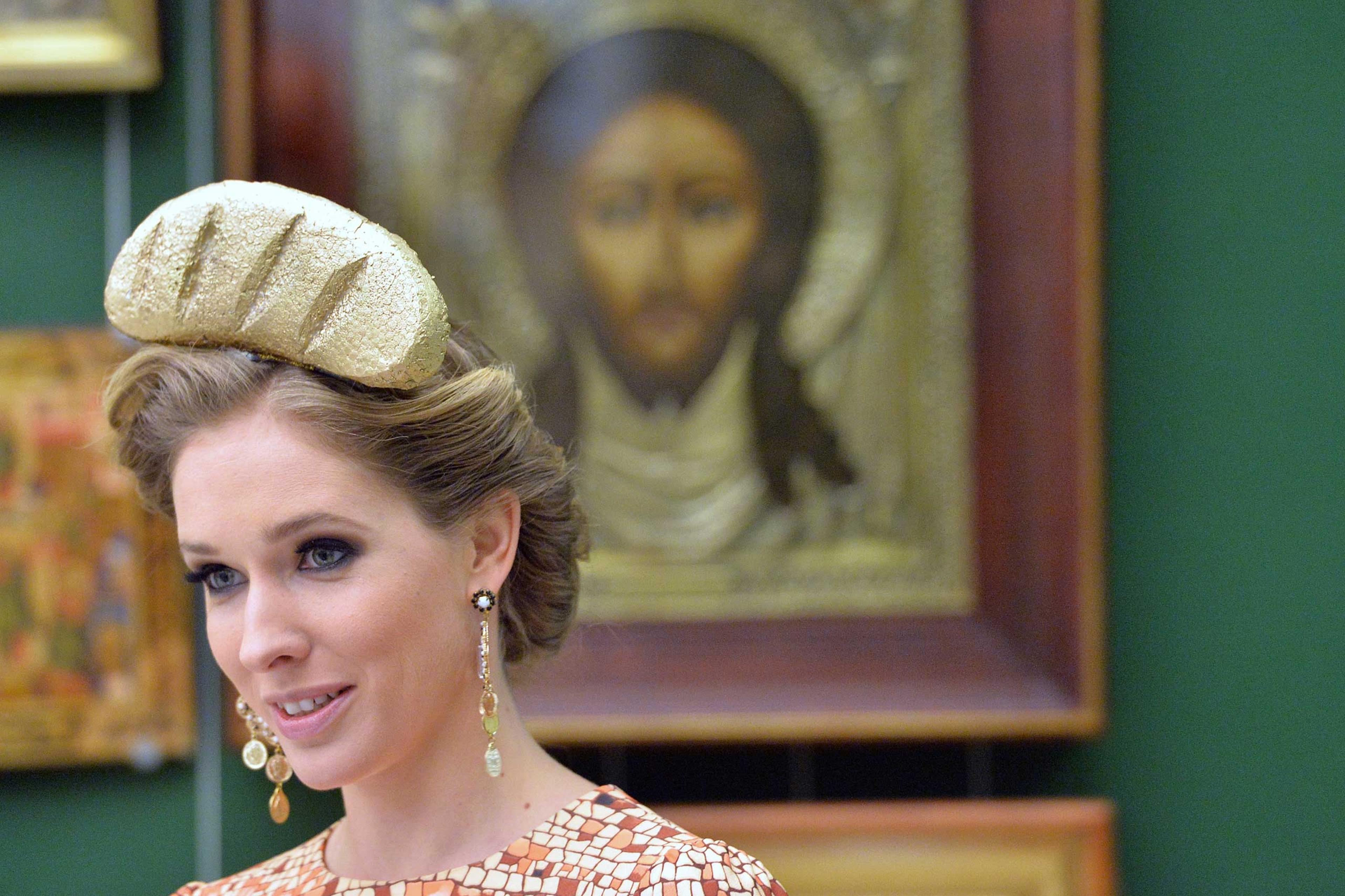 A visitor of the National Art Museum of Ukraine in Kiev wears a decoration depicting the so called "Golden loaf" found in the residence of former Ukrainian President Yanukovych residence, during the opening of an exhibition on April 25, 2014.