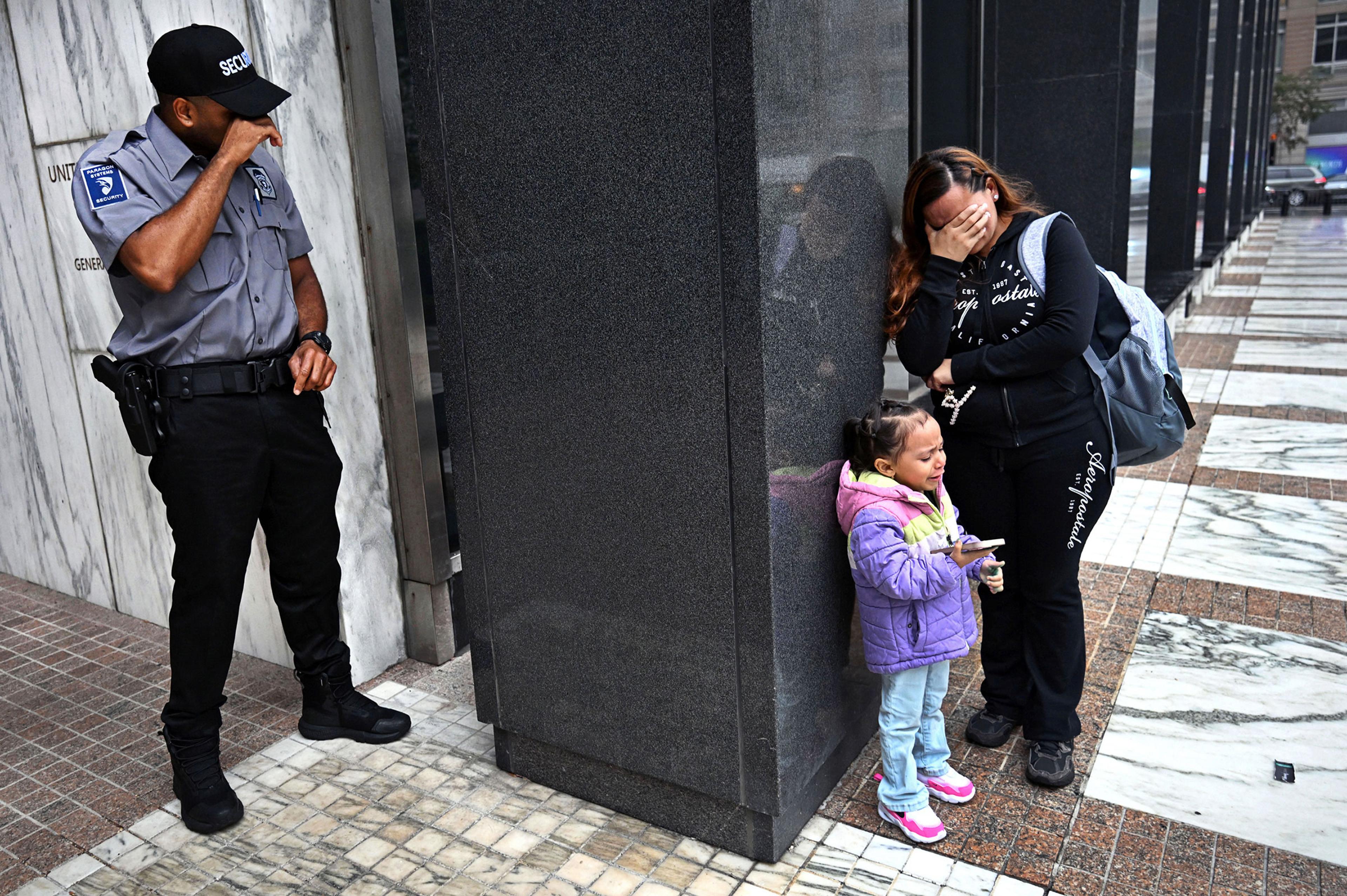 After her husband was detained by ICE agents on Aug. 20, a woman with her child wept outside a federal building in New York City; a security guard was moved to tears as well. There was no word at the time on whether the detained man faced any criminal charges.