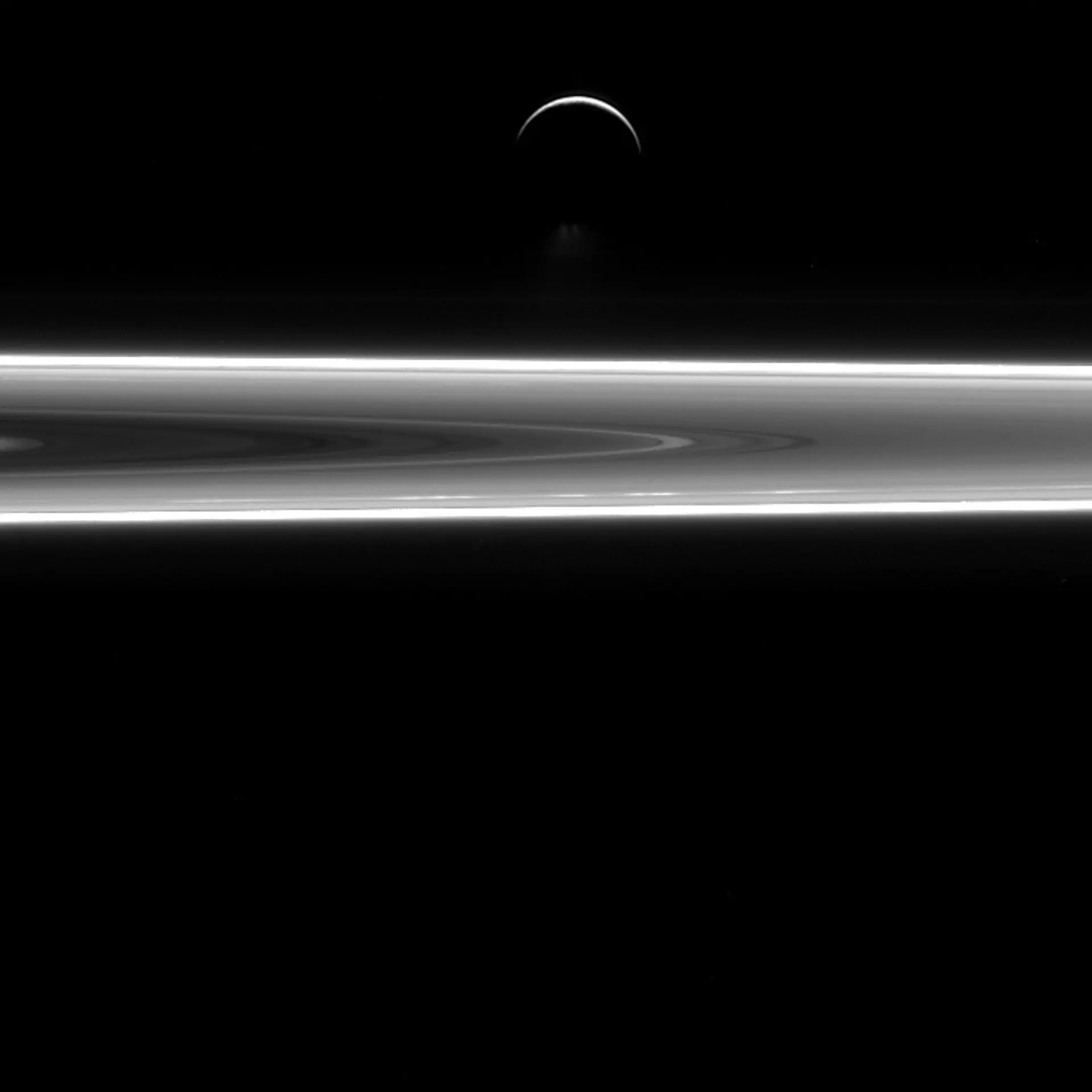 Enceladus over Saturn's rings.
