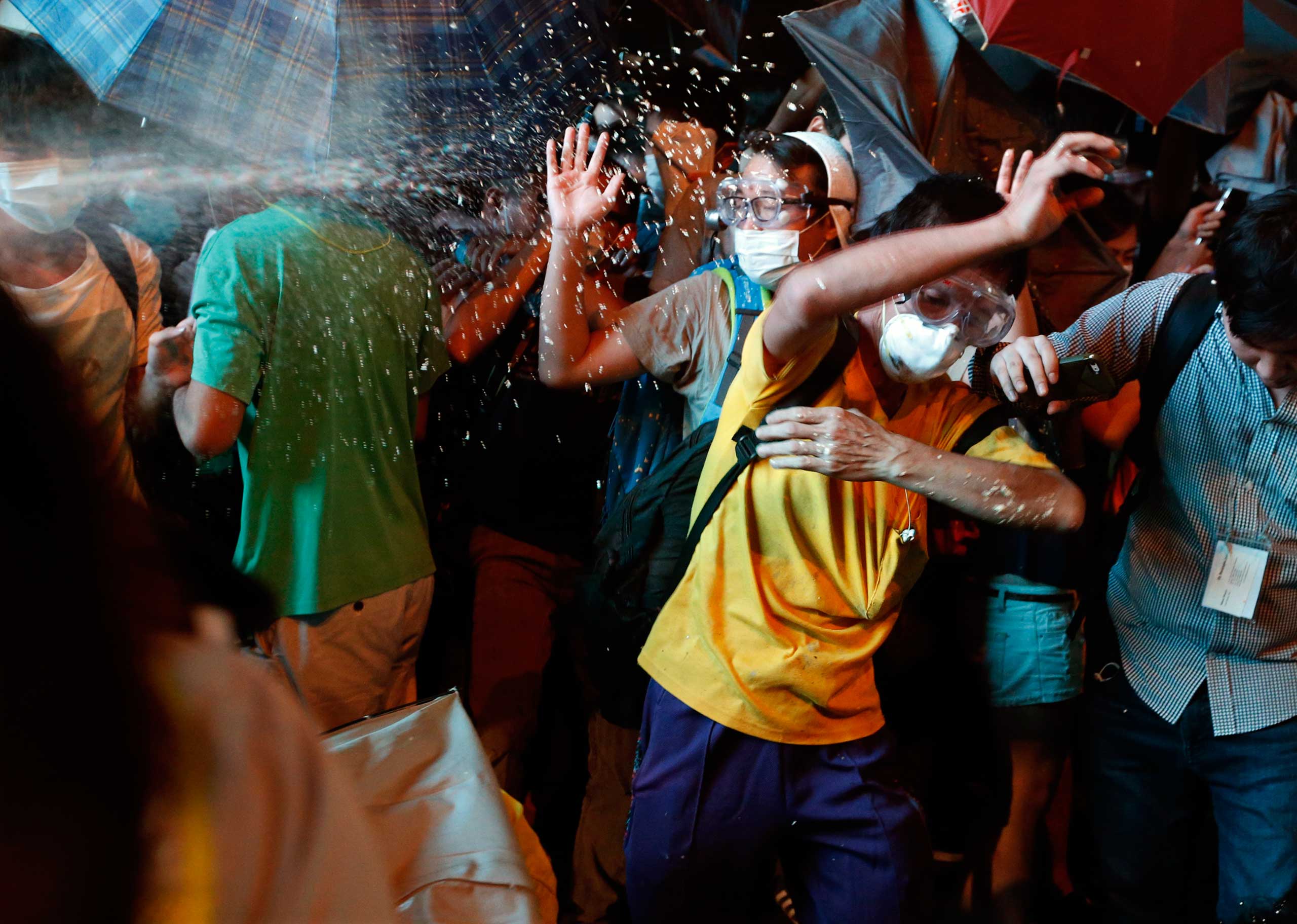 Protesters are pepper sprayed by riot police during a confrontation at Mongkok shopping district in Hong Kong