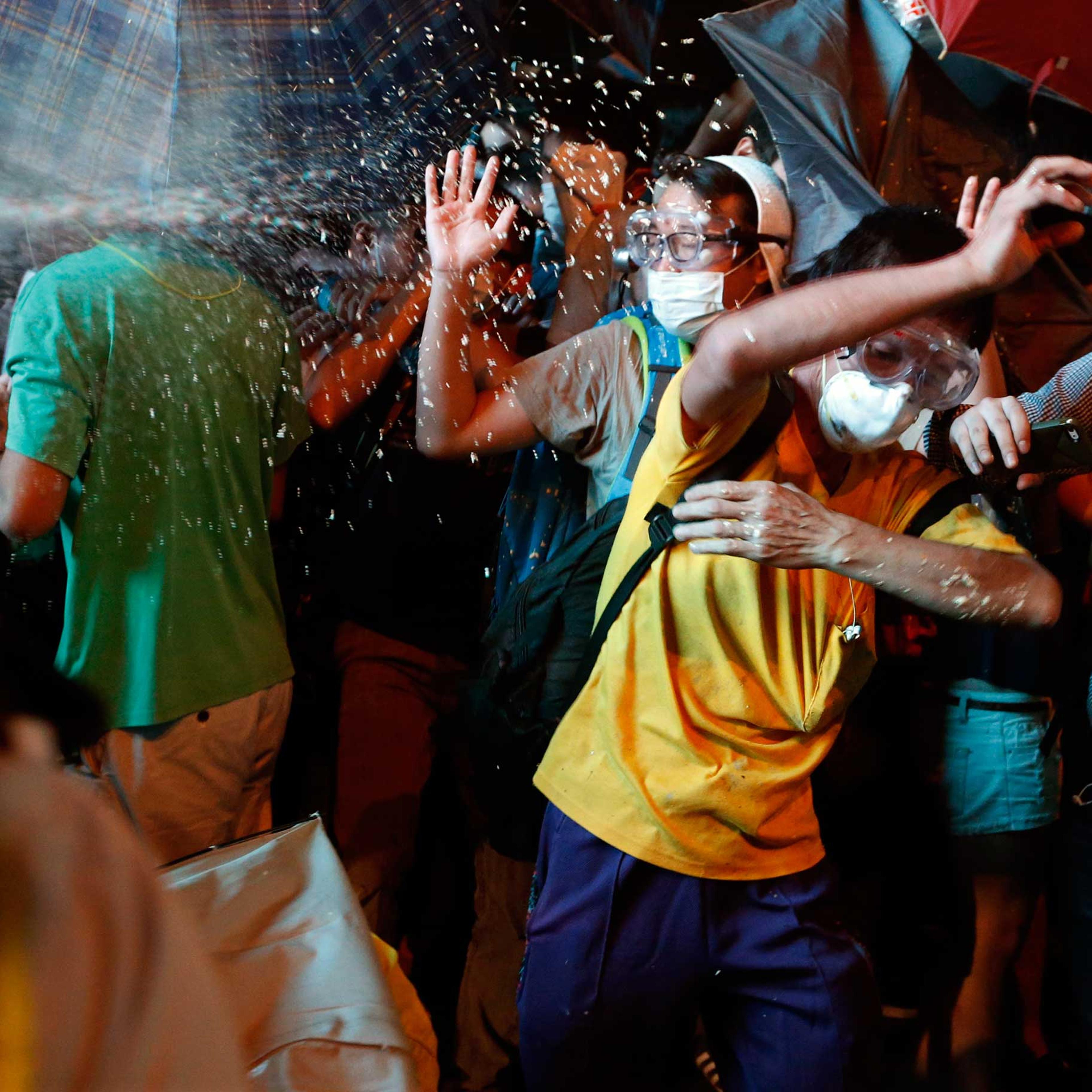 Protesters are pepper sprayed by riot police during a confrontation at Mongkok shopping district in Hong Kong