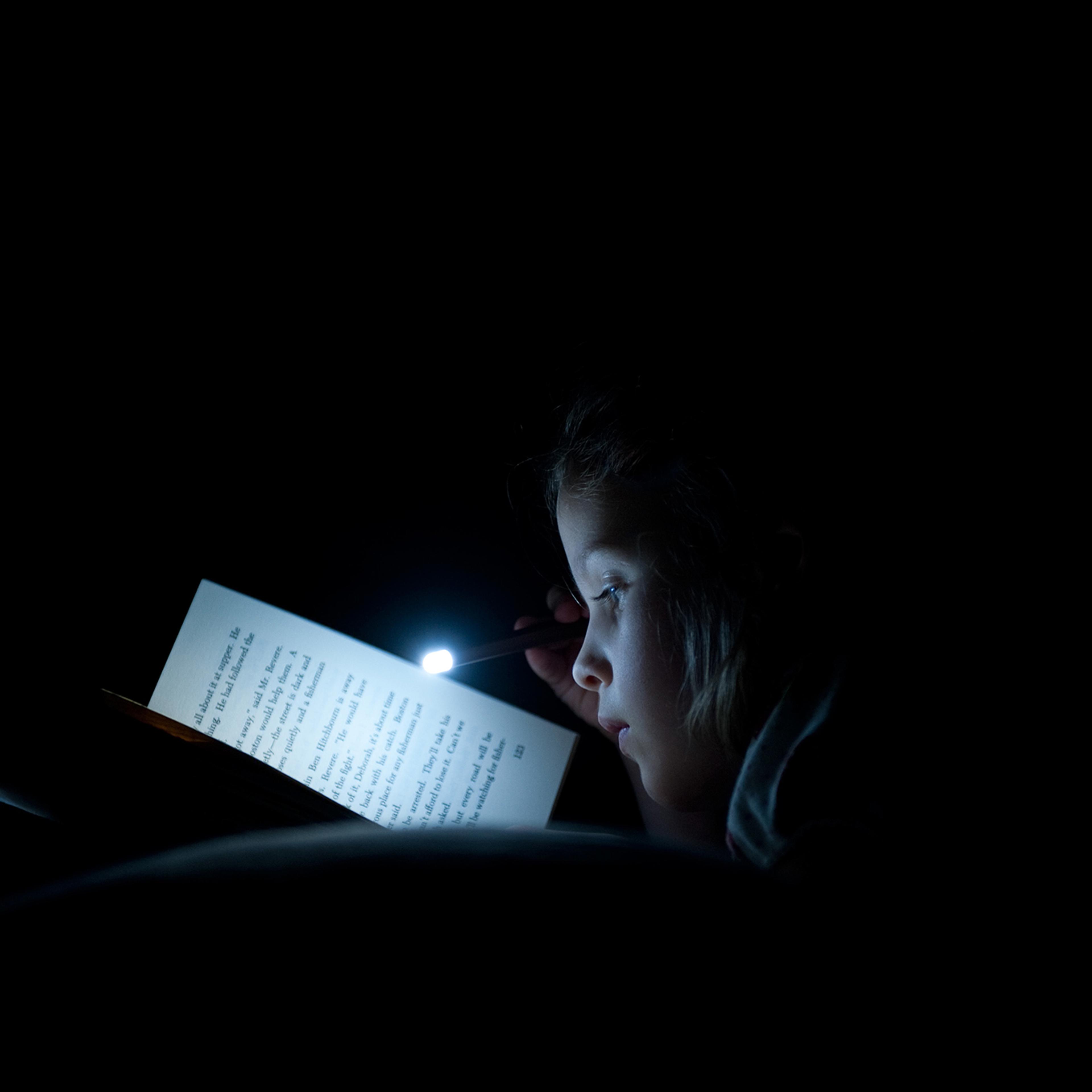 Girl Reading Book with Small Flashlight