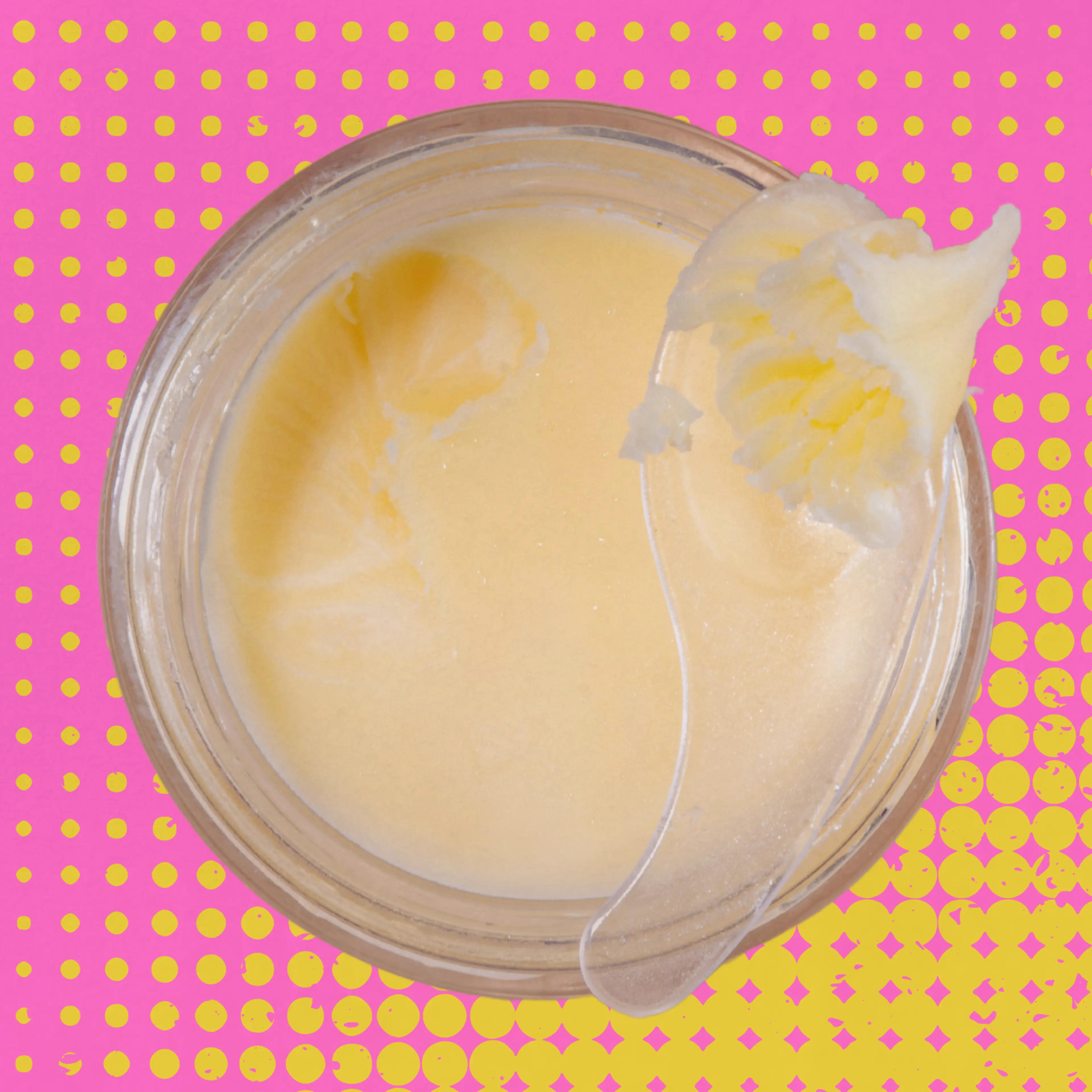 Beef tallow in a jar against a pink backdrop with yellow polka dots.