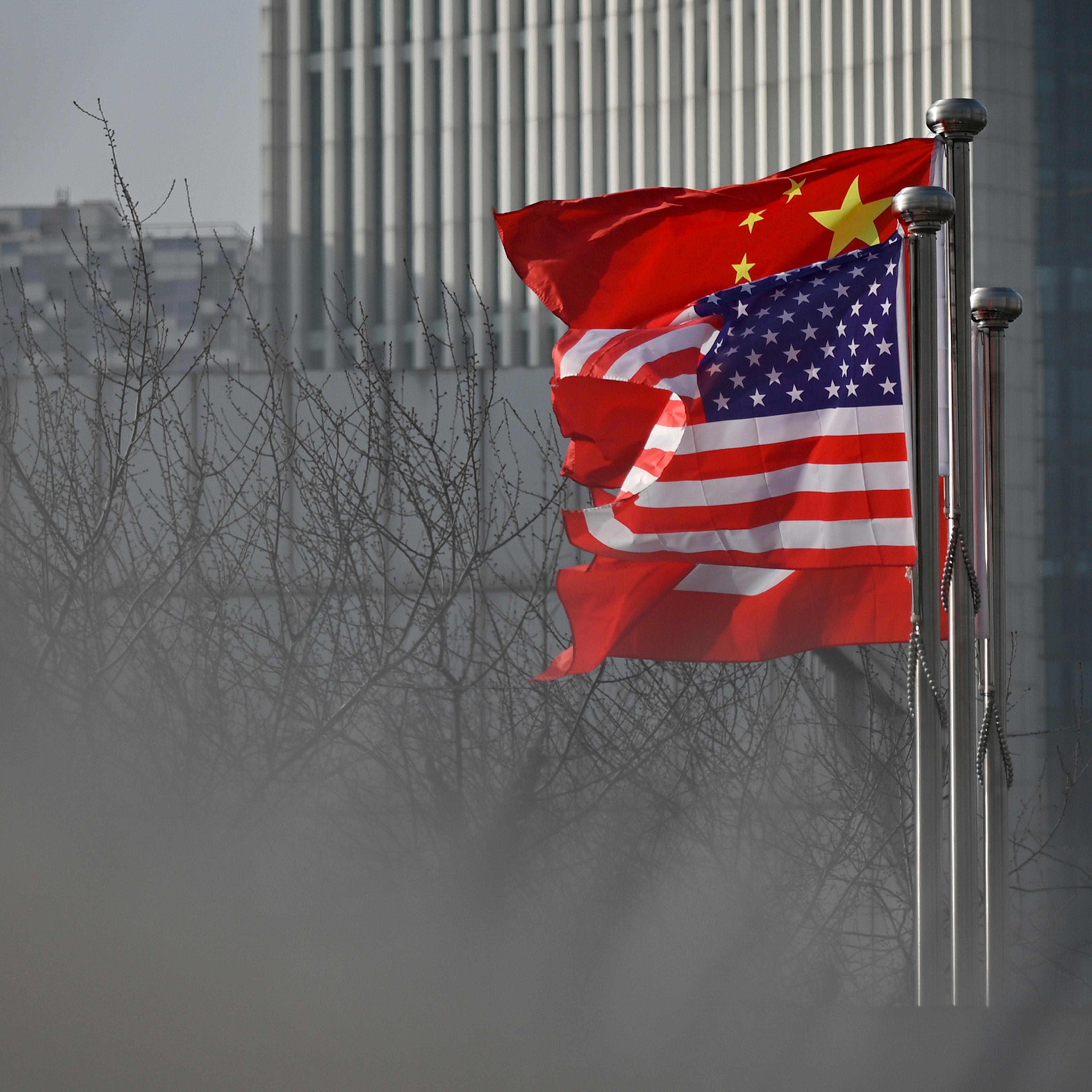 Chinese and U.S. national flags flutter at the entrance of an office building in Beijing on Jan. 19, 2020.