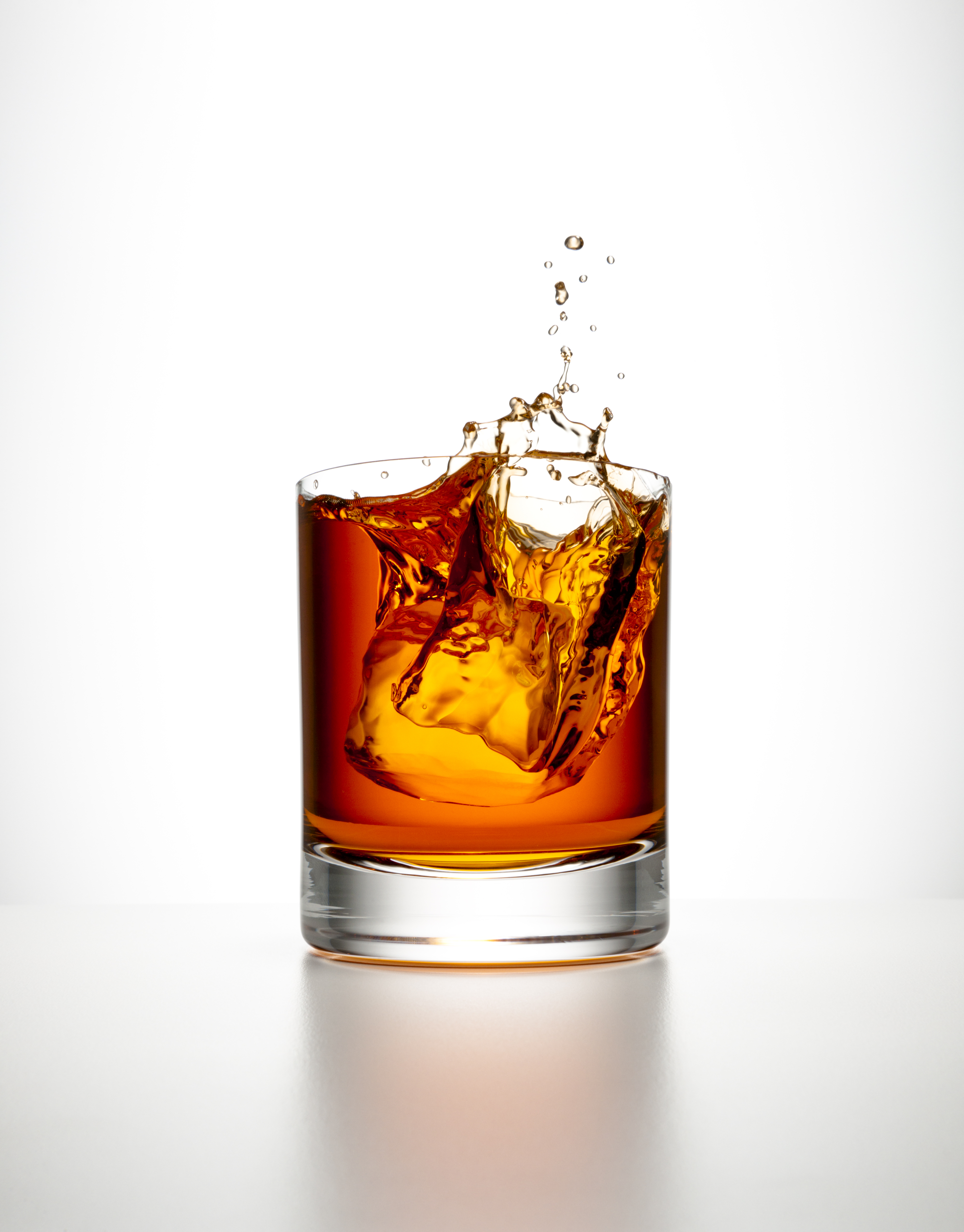 Ice cube splashing into a glass