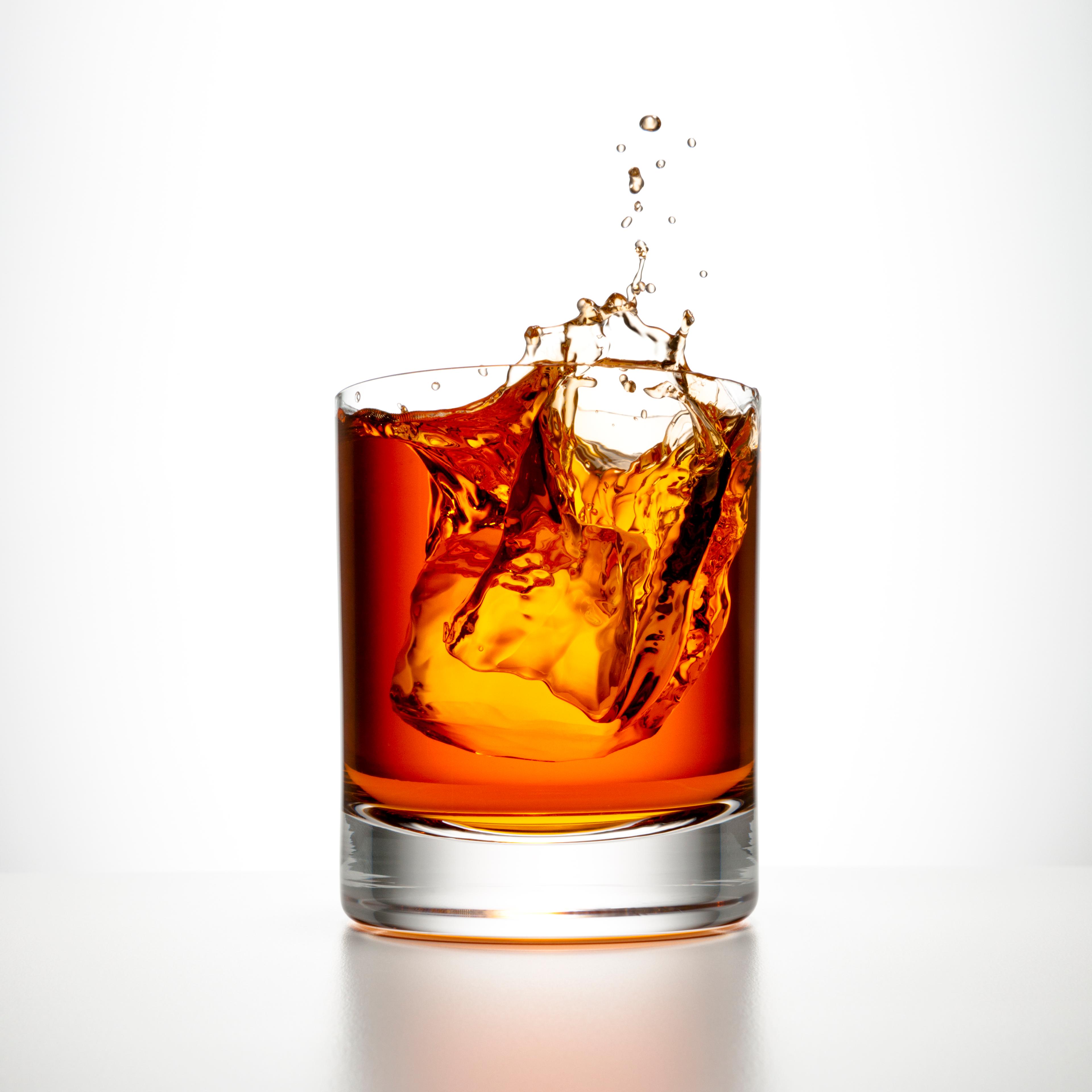 Ice cube splashing into a glass