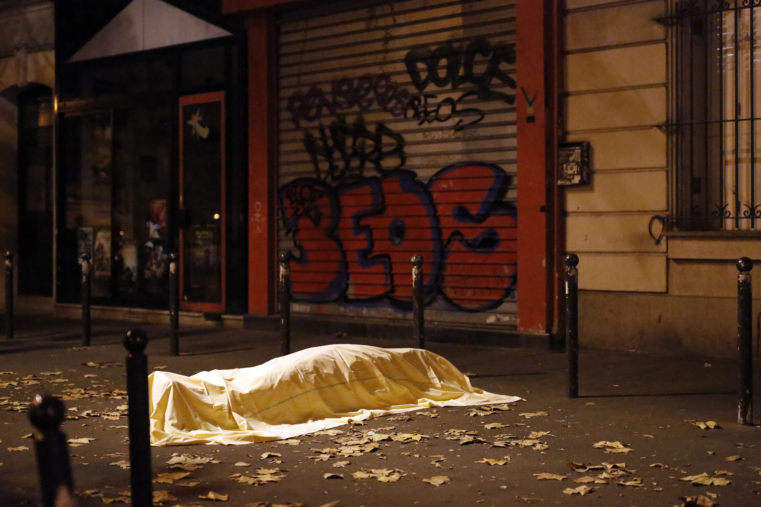 A victim of an attack at the Bataclan music hall lays dead outside the theater, Paris, Nov. 13, 2015. Eighty-nine people were killed in that attack, one of several throughout the night across Paris that killed 130.