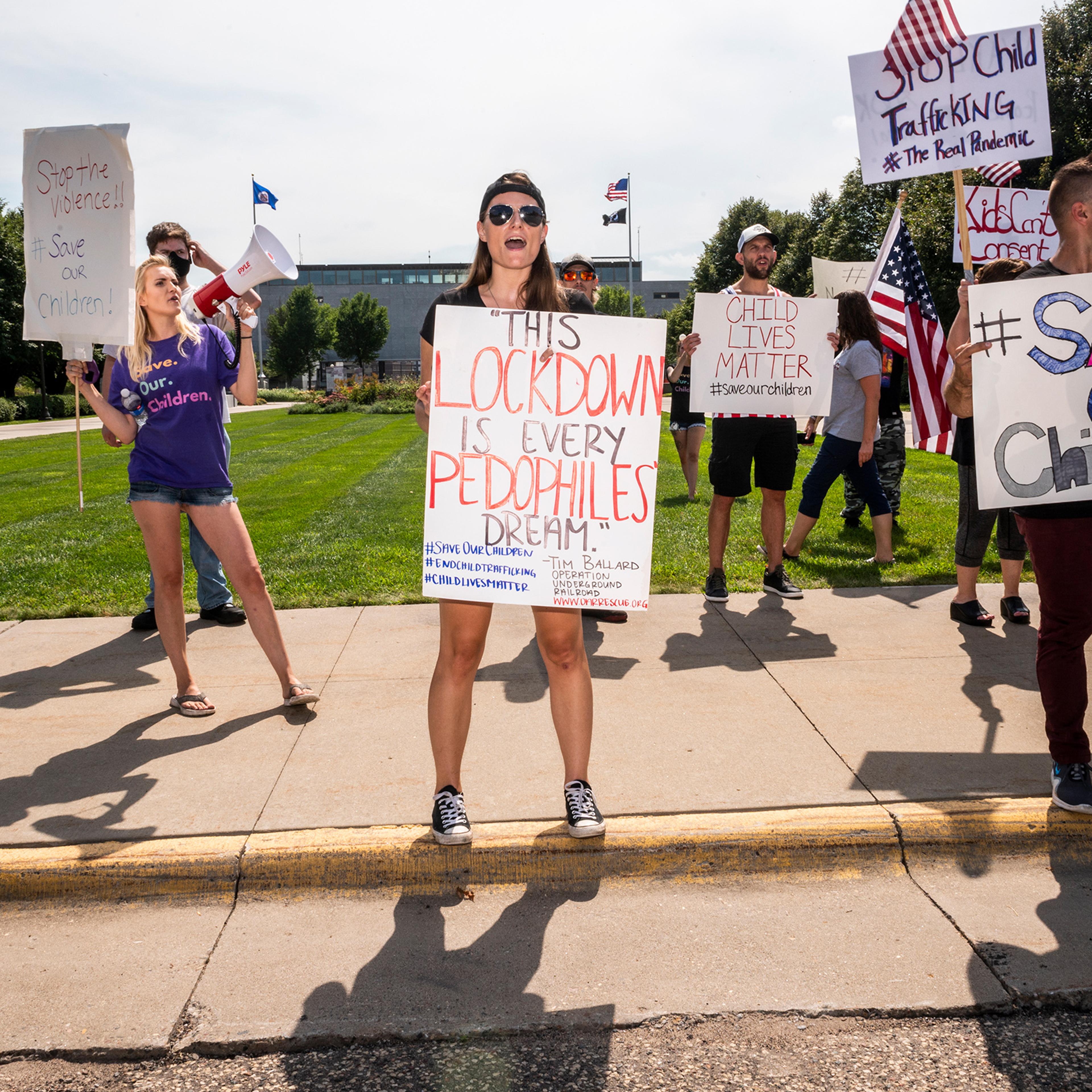 At an Aug. 22 “Save the Children” rally in St. Paul, Minn., protesters trumpet elements of the QAnon conspiracy theory