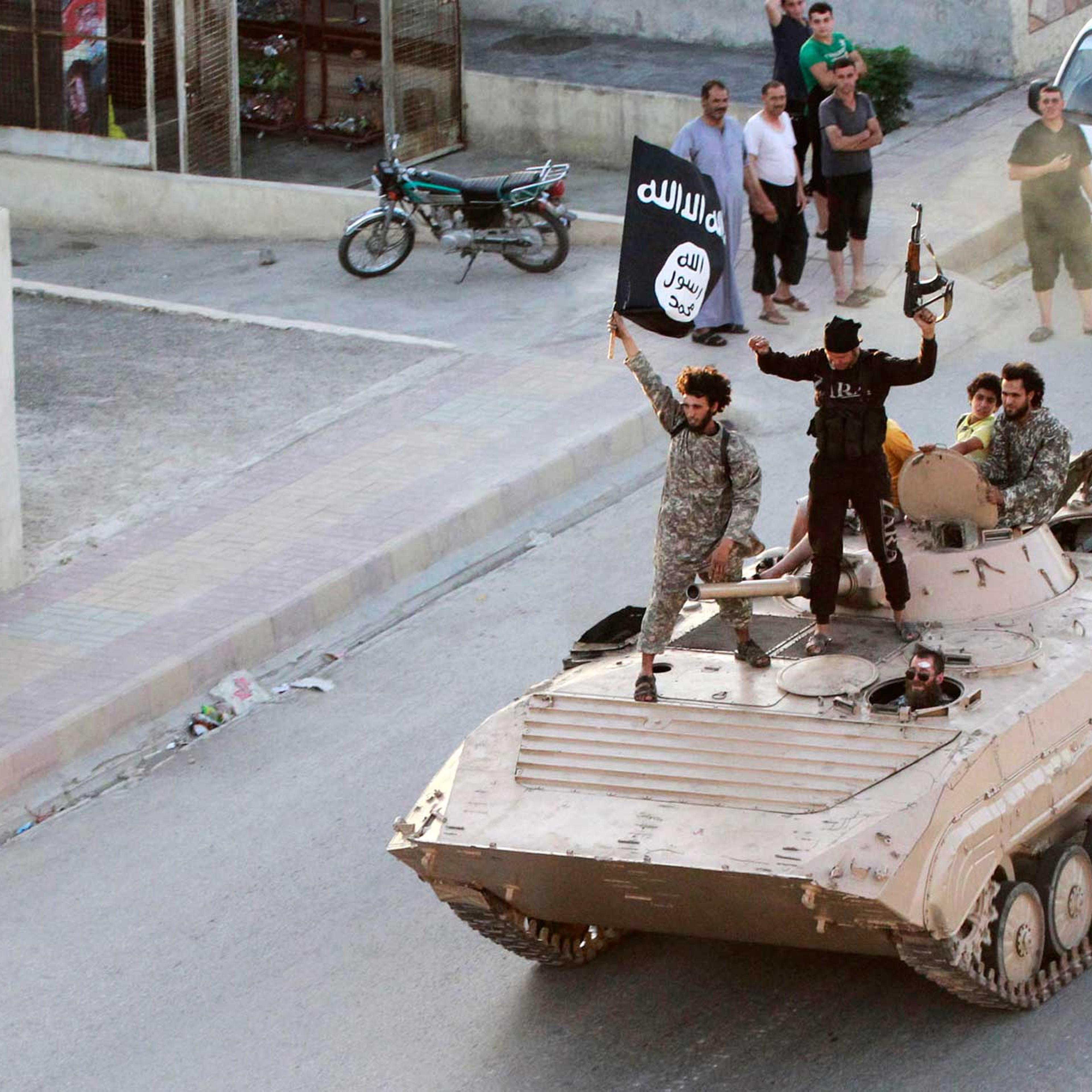 Militant Islamist fighters take part in a military parade along the streets of northern Raqqa province, June 2014.