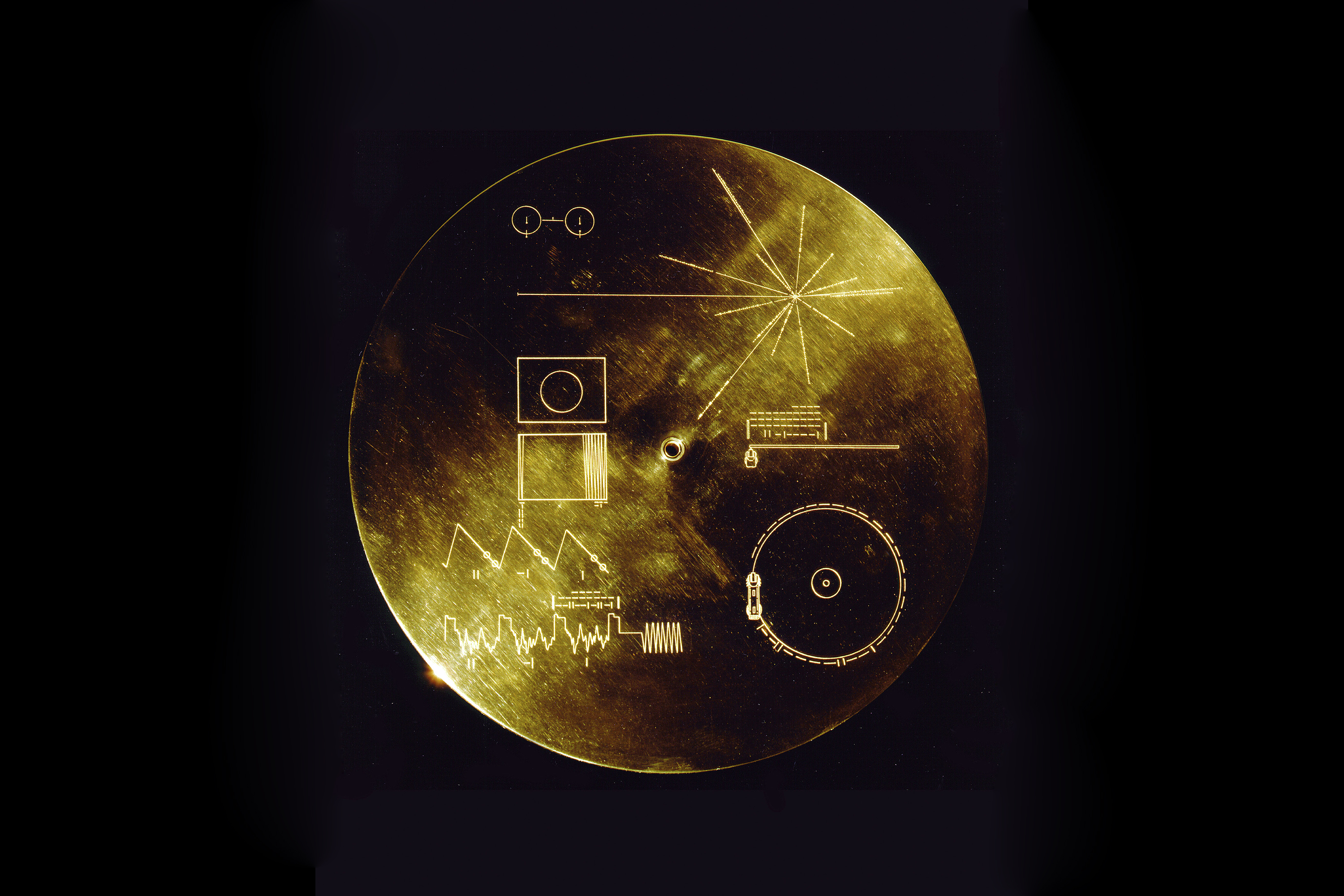 This gold aluminum cover was designed to protect the Voyager 1 and 2 'Sounds of Earth' gold-plated record from micrometeorite bombardment, but also serves a double purpose in providing the finder a key to playing the record. The explanatory diagram appea
