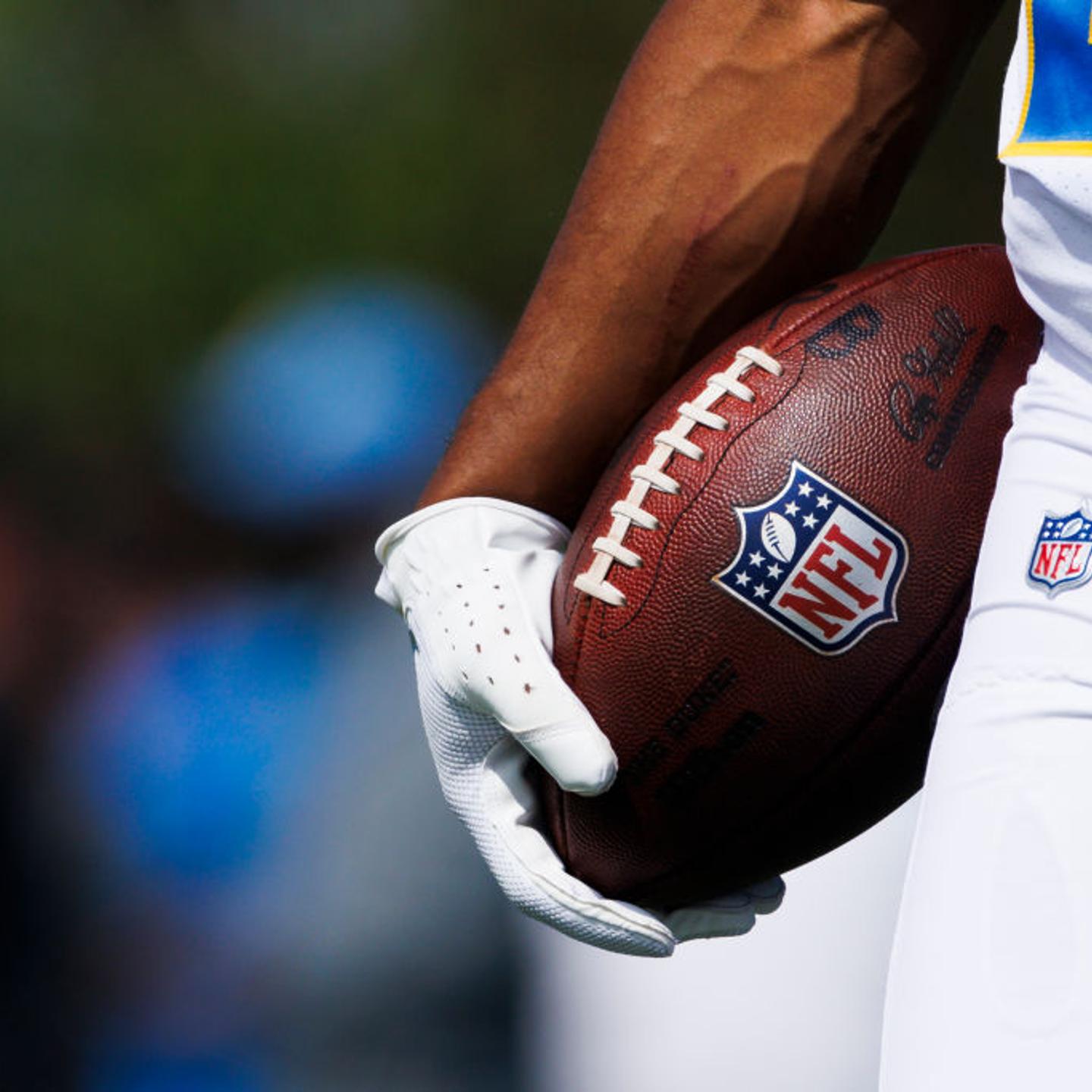 A Los Angeles Chargers player holding a football with the NFL logo during practice at Hoag Performance Center in Costa Mesa, California, on June 13, 2024.