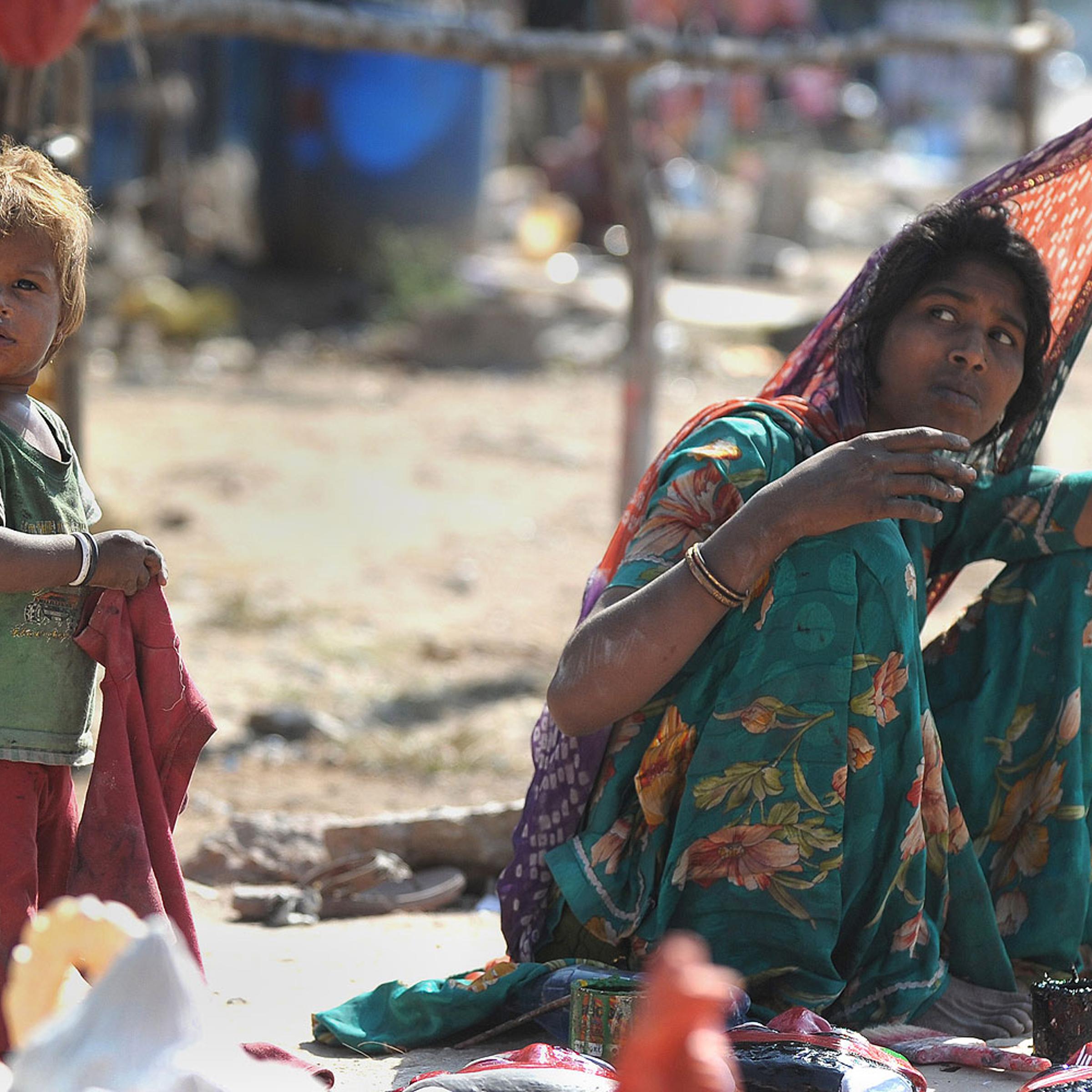 An Indian labourer sits with a child outside a makeshift shelter on a highway on the outskirts of Hyderabad on Nov. 14, 2013