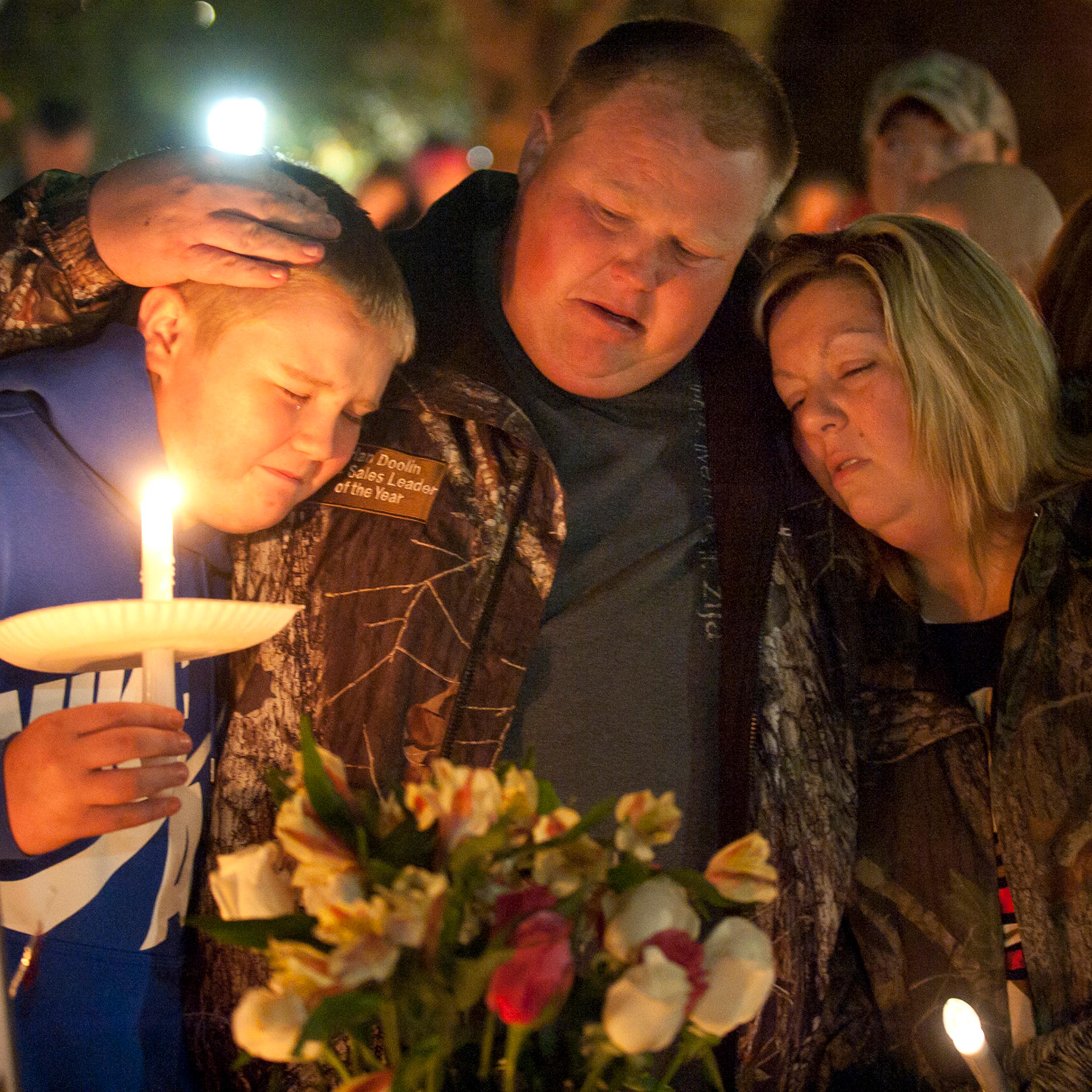 Gabriella Doolin's brother Alec, father Brian and mother Amy, comfort each other during a vigil for her in Scottsville, Kentucky on Nov. 15, 2015.