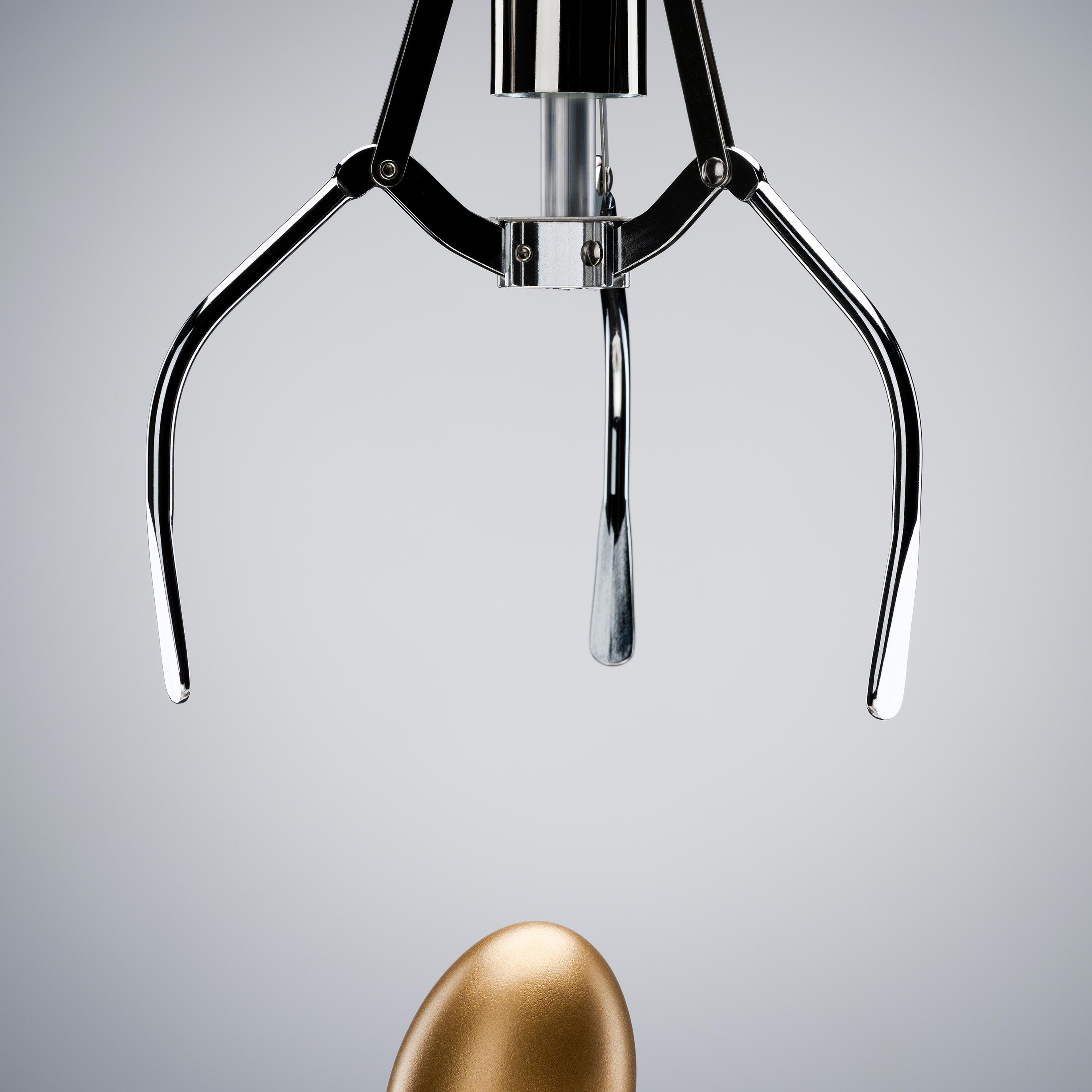 Mechanical claw reaching for golden egg