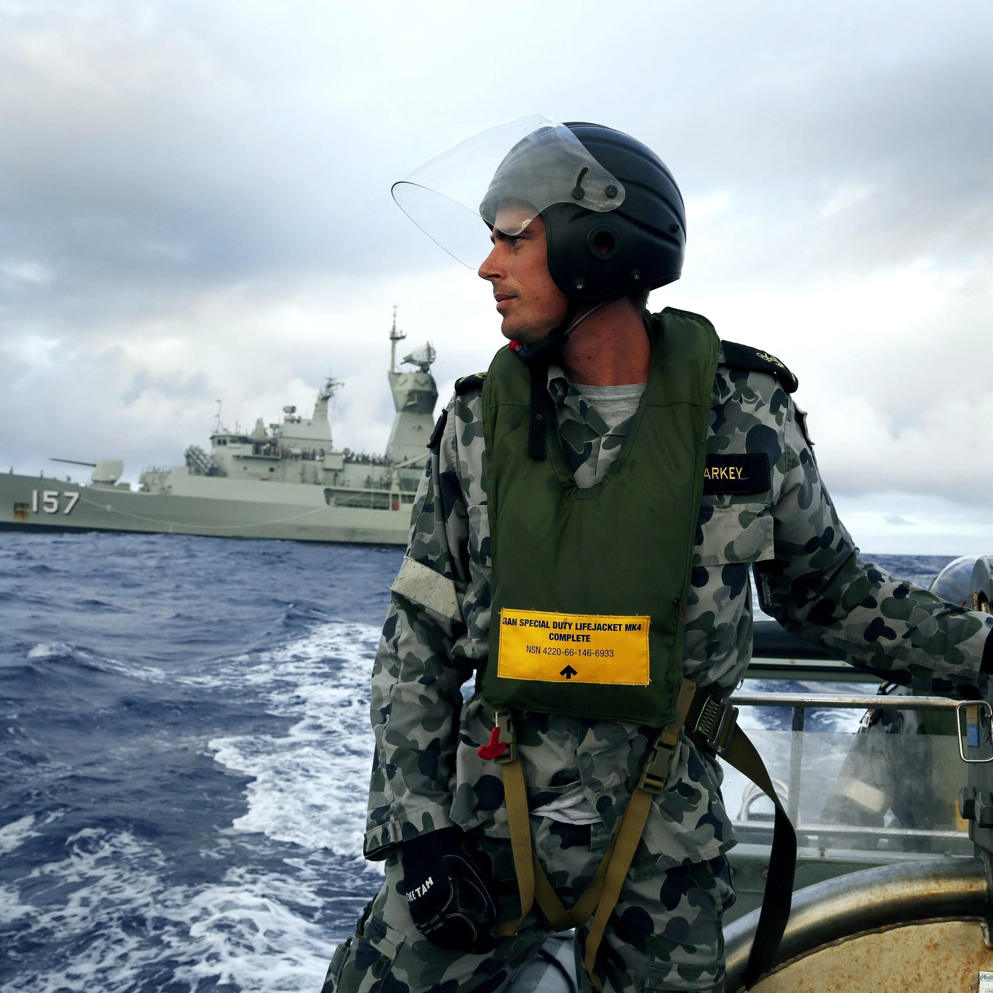 Leading Seaman, Boatswain's Mate, William Sharkey searches for debris at sea in the Southern Indian Ocean on April 6, 2014.