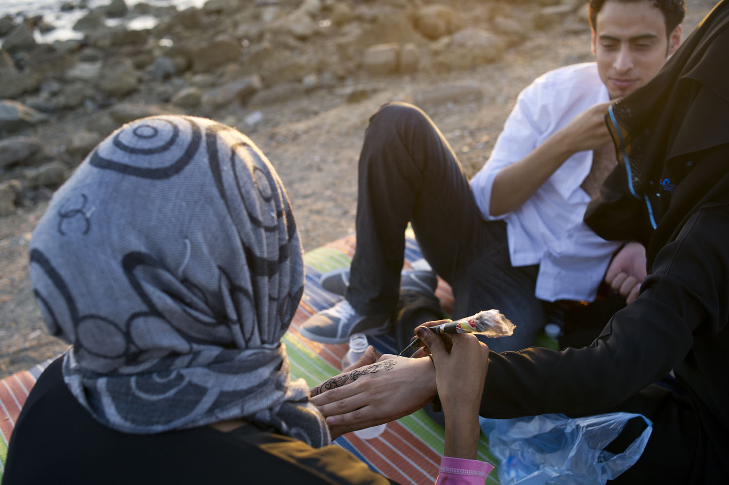 A woman has her hand painted with henna along the corniche in Jeddah, Saudi Arabia, June 14, 2011.  Because of cultural and religious restrictions imposed on women in Saudi Arabia, women generally need a male guardian to accompany them out in public, and are often fully veiled as per tradition in Saudi Arabia.