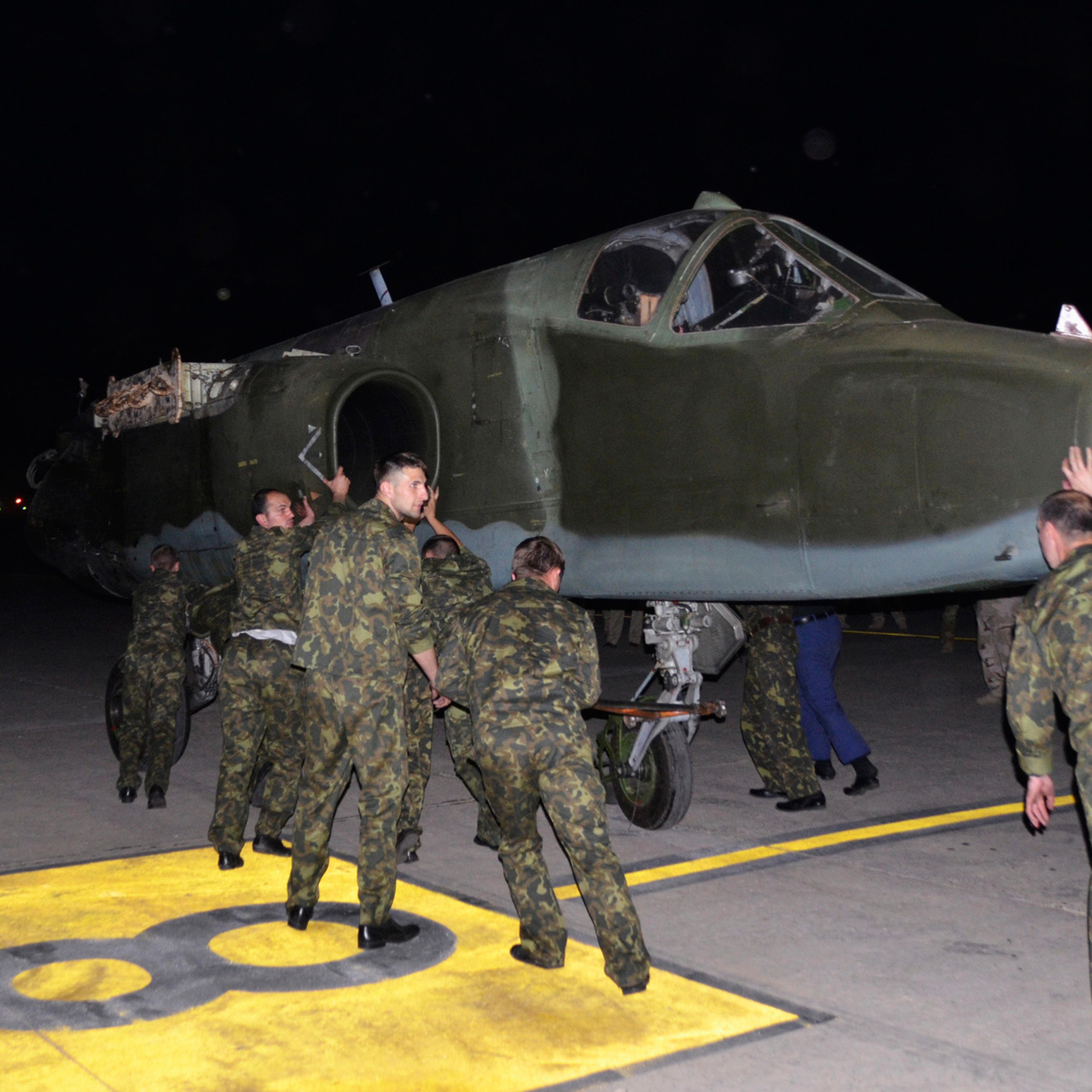 Russian soldiers unload Russian Sukhoi SU-25 plane in al-Muthanna Iraqi military base at Baghdad airport in Baghdad