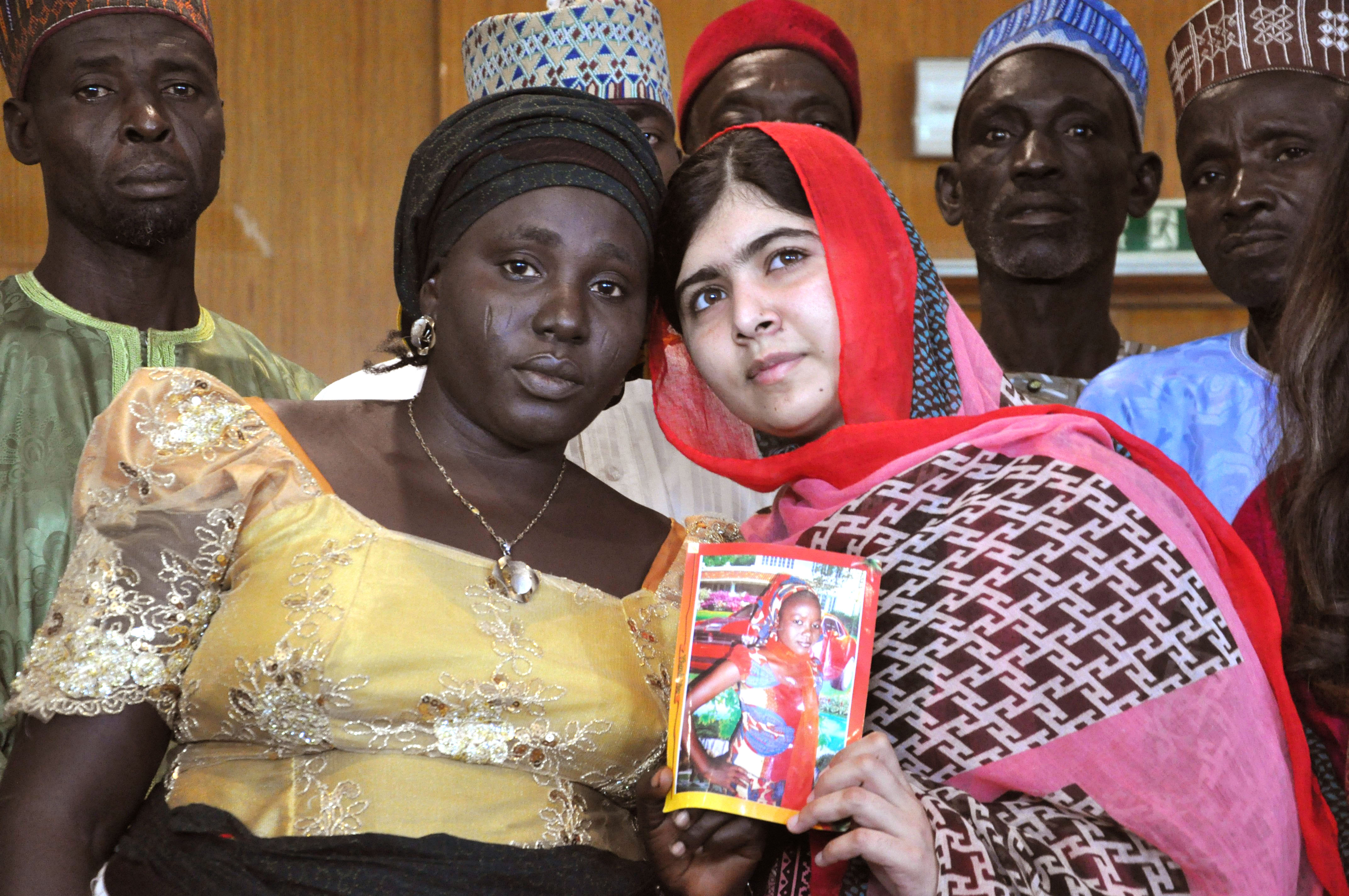 From right: Pakistani activist Malala Yousafzai holds a picture of kidnapped schoolgirl Sarah Samuel with her mother Rebecca Samuel during a visit to Abuja, Nigeria on July 13, 2014.