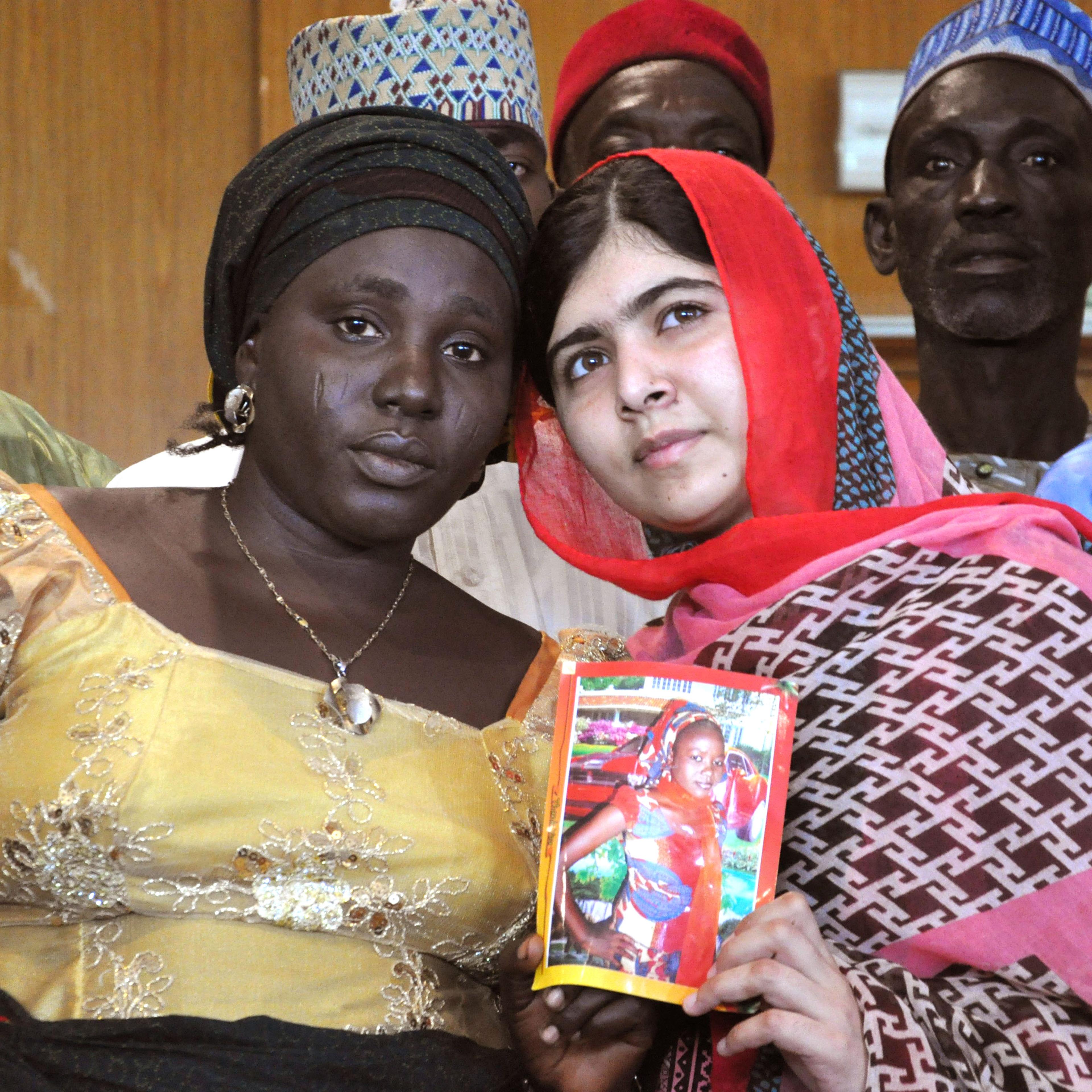 From right: Pakistani activist Malala Yousafzai holds a picture of kidnapped schoolgirl Sarah Samuel with her mother Rebecca Samuel during a visit to Abuja, Nigeria on July 13, 2014.