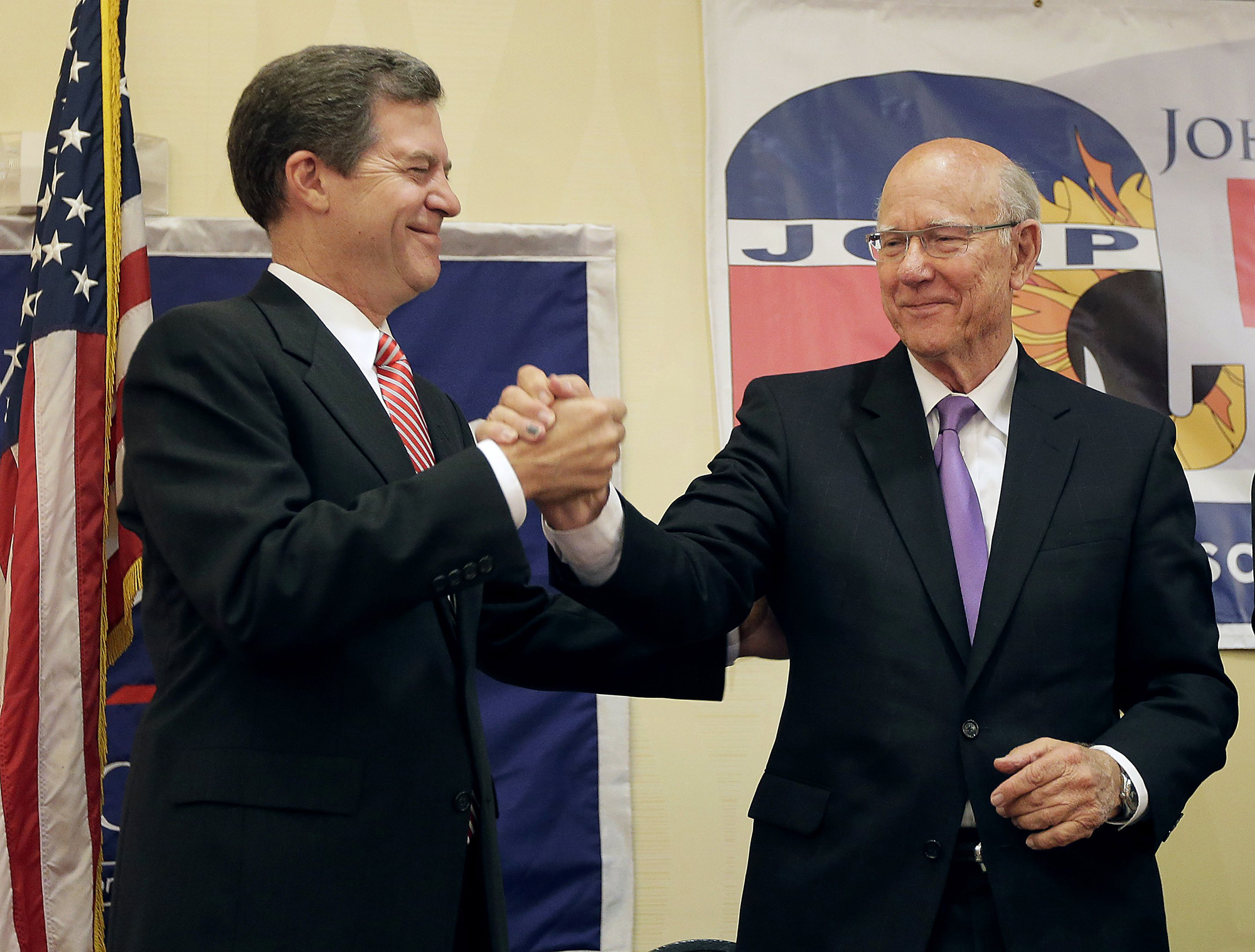 Kansas Gov. Sam Brownback, left, and U.S. Sen. Pat Roberts greet each other at Johnson County Republican's election watch party Tuesday, Aug. 5, 2014, in Overland Park, Kan.