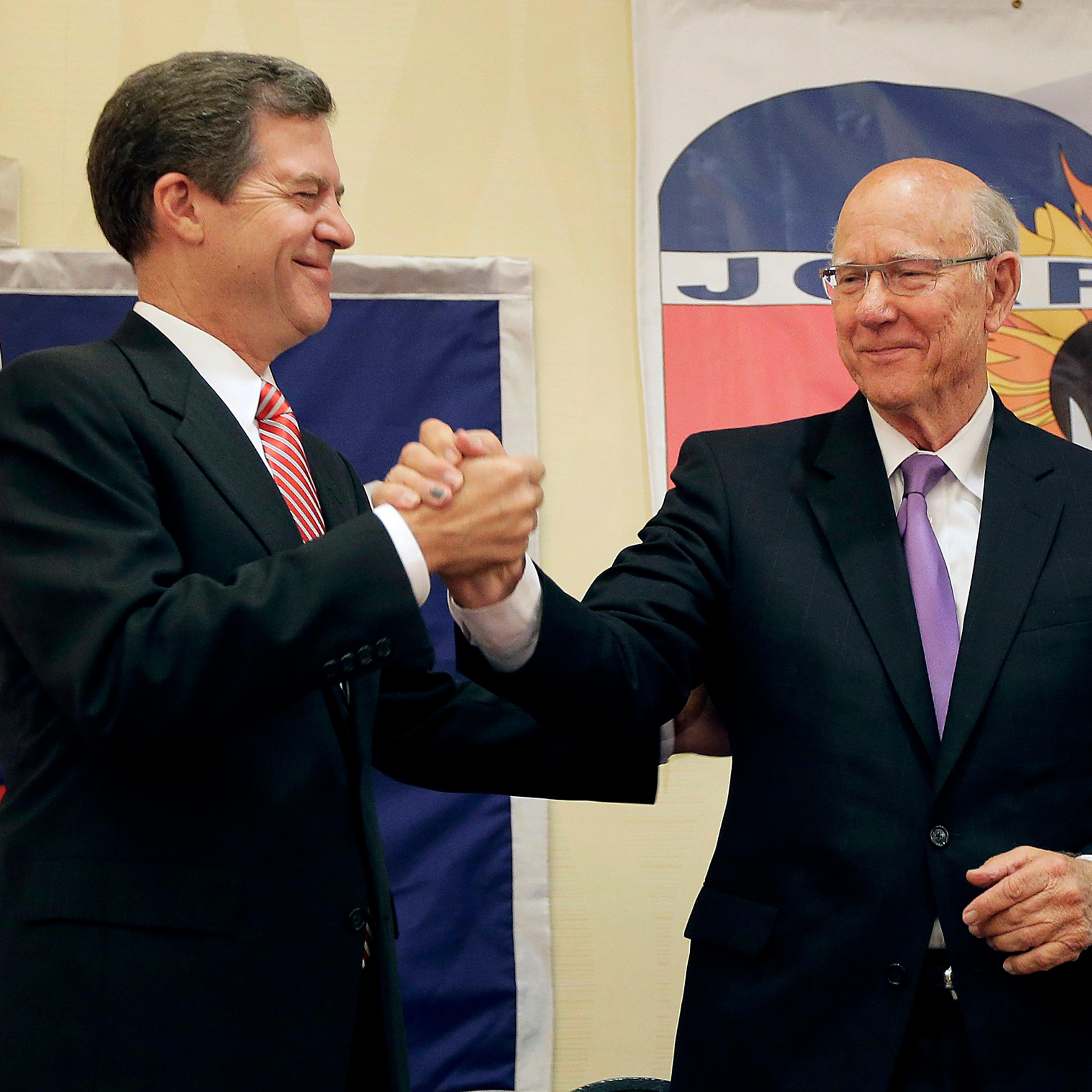 Kansas Gov. Sam Brownback, left, and U.S. Sen. Pat Roberts greet each other at Johnson County Republican's election watch party Tuesday, Aug. 5, 2014, in Overland Park, Kan.