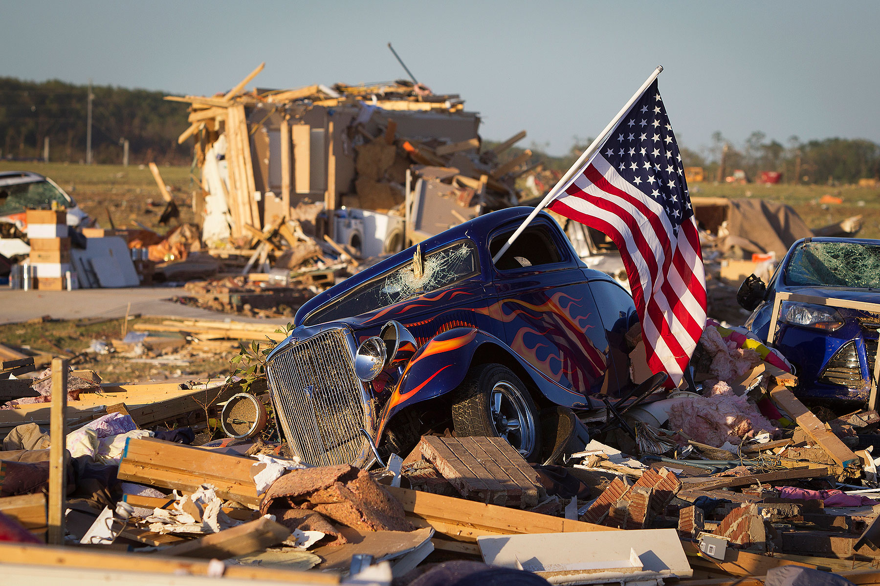 A U.S. flag sticks out the window of a damaged hot rod car in a suburban area after a tornado near Vilonia, Arkansas April 28, 2014