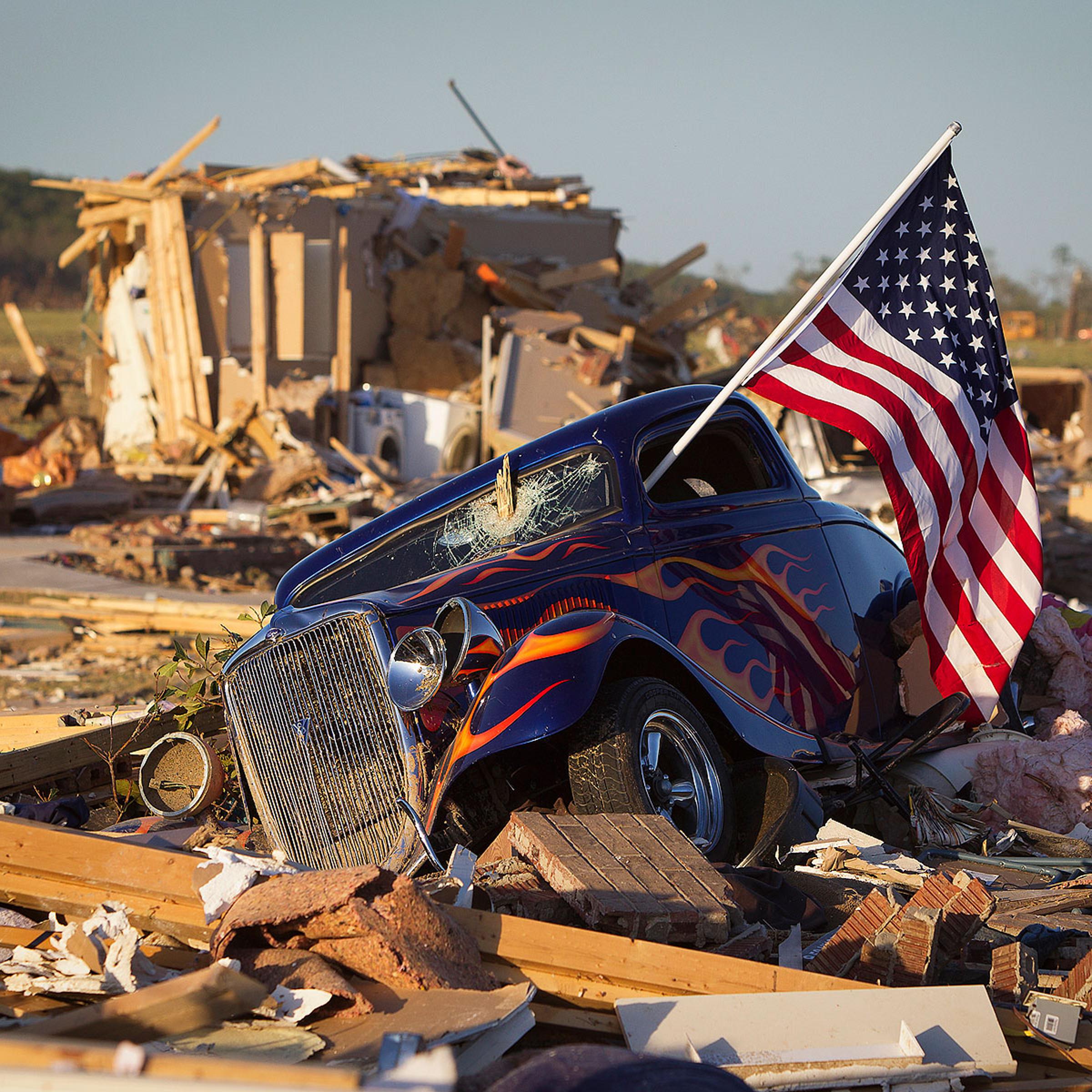 A U.S. flag sticks out the window of a damaged hot rod car in a suburban area after a tornado near Vilonia, Arkansas April 28, 2014