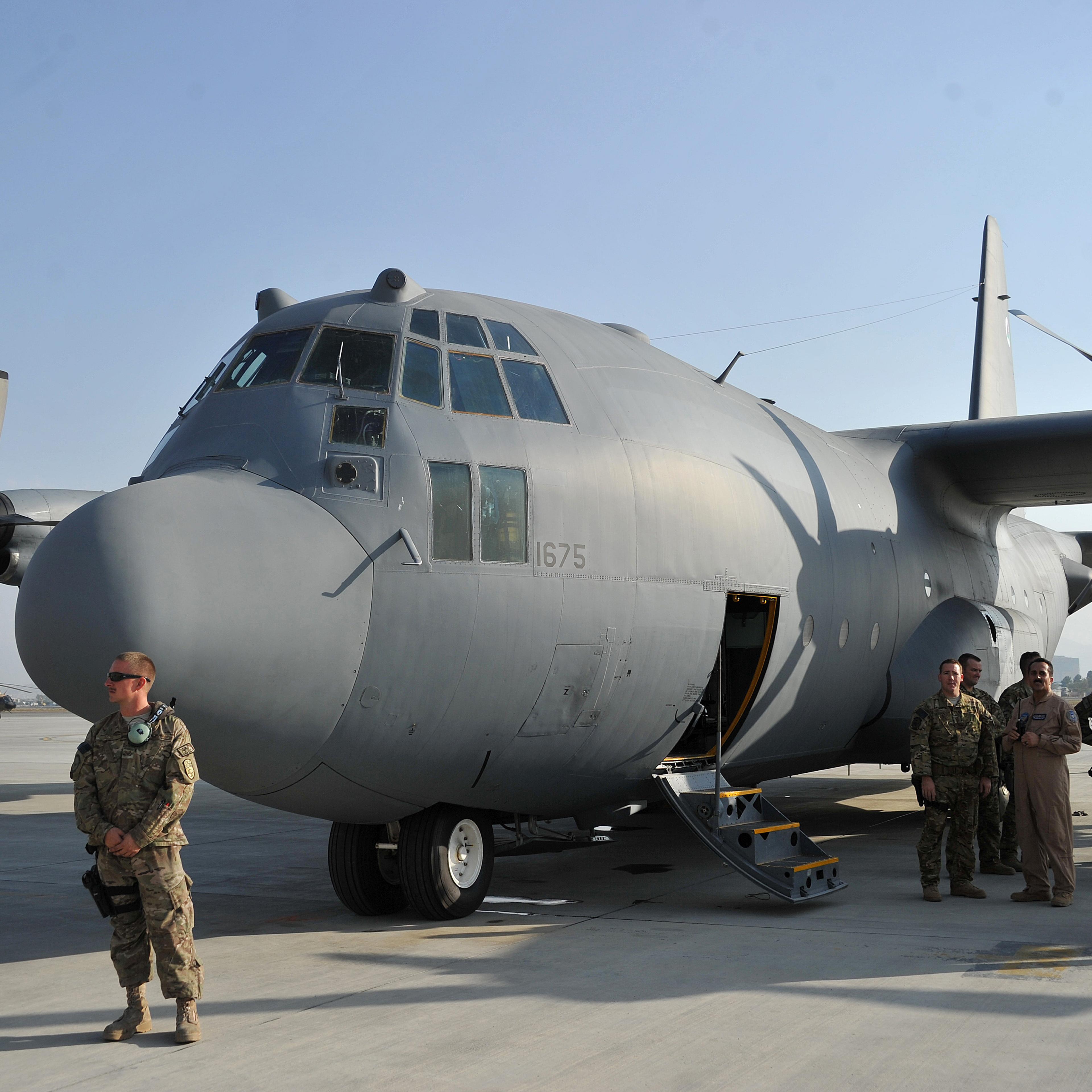 Members of the US Air Force stand alongside a C-130 transport aircraft at Kabul international airport on October 9, 2013.