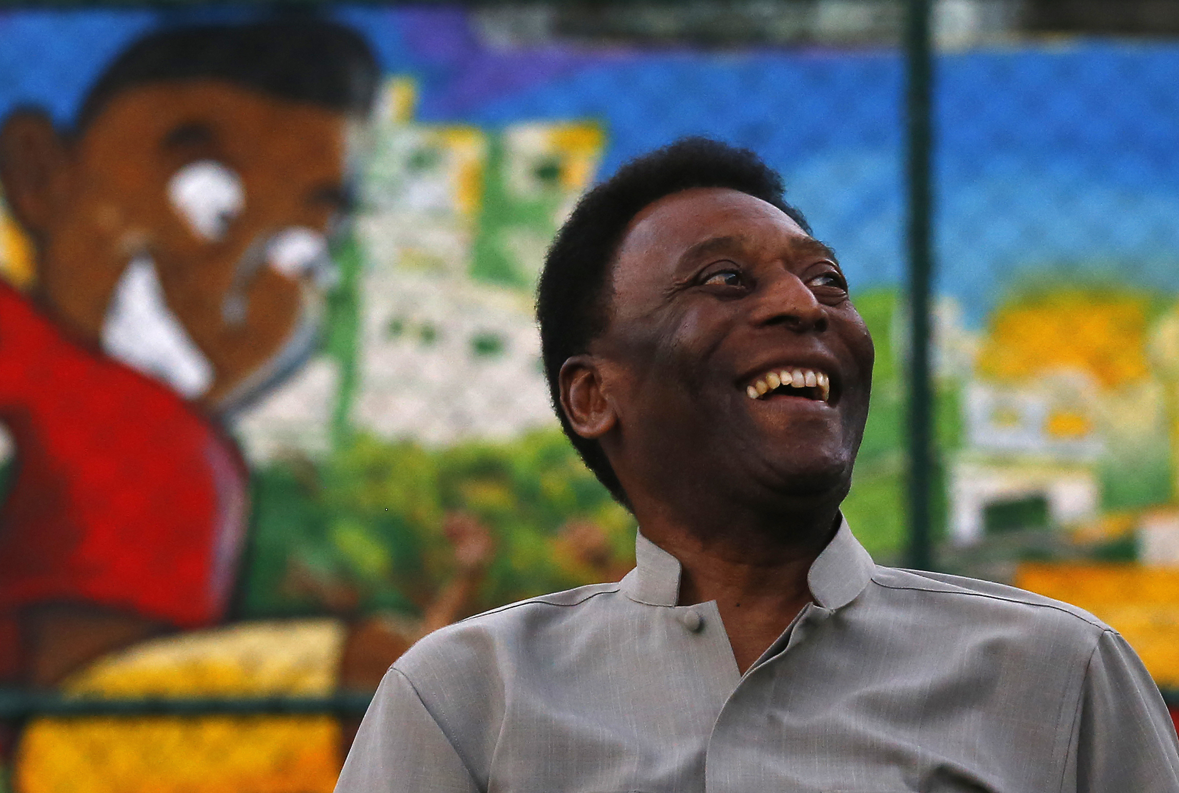 Brazilian soccer legend Pele laughs during the inauguration of a refurbished soccer field at the Mineira slum in Rio de Janeiro