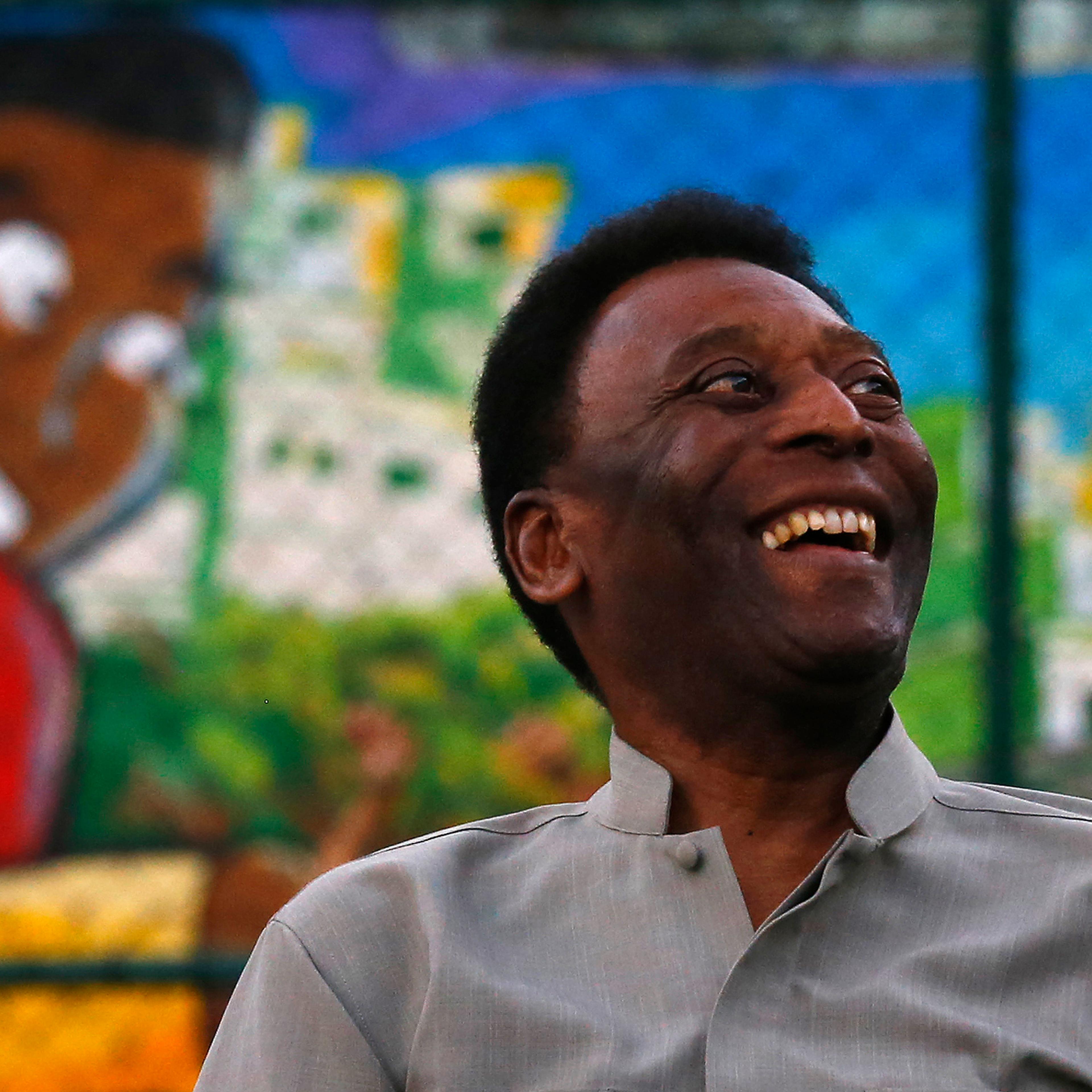 Brazilian soccer legend Pele laughs during the inauguration of a refurbished soccer field at the Mineira slum in Rio de Janeiro