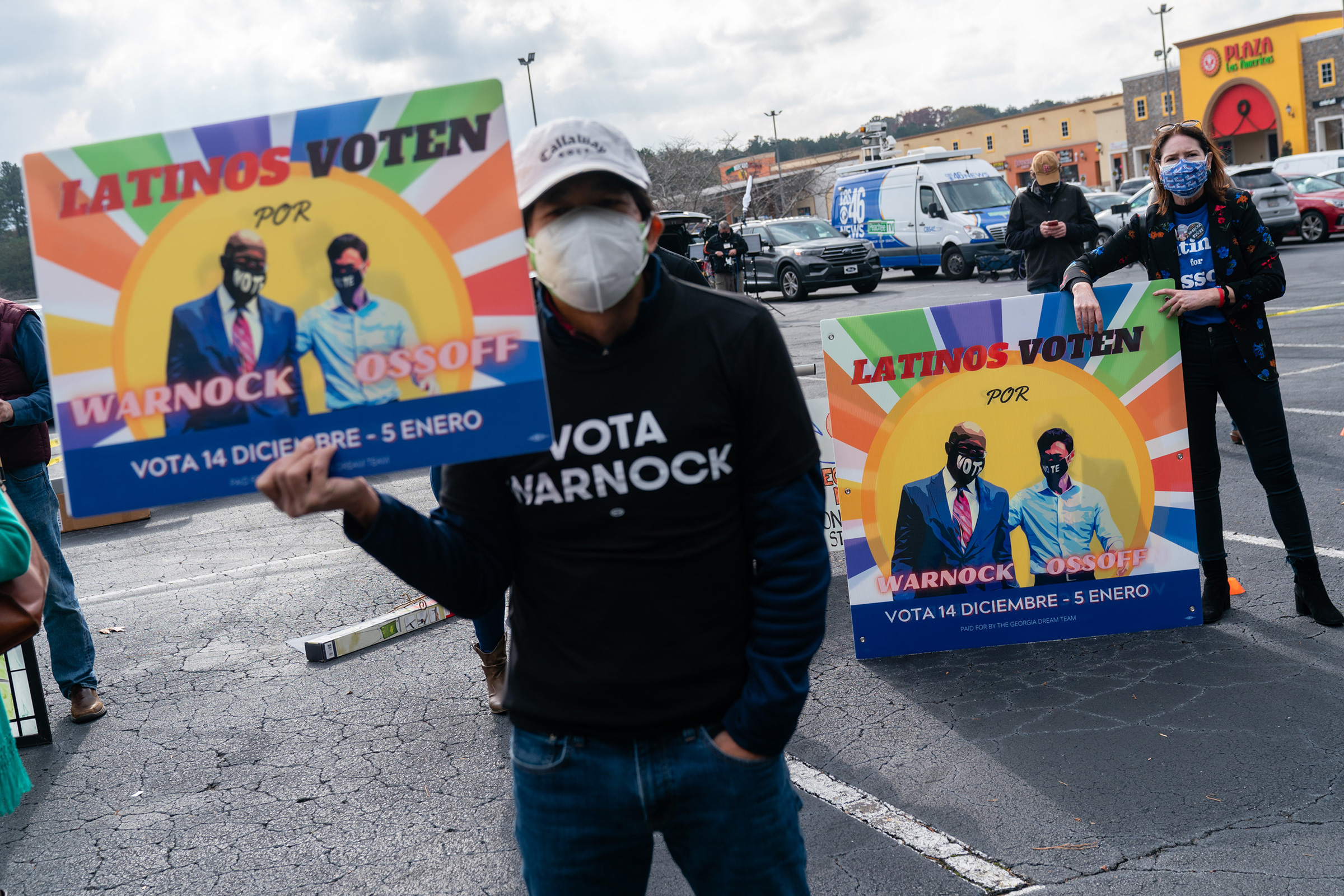Attendees hold signs during a campaign event for Democratic Senate candidate Jon Ossoff in Lilburn, Georgia, on Dec. 7. R