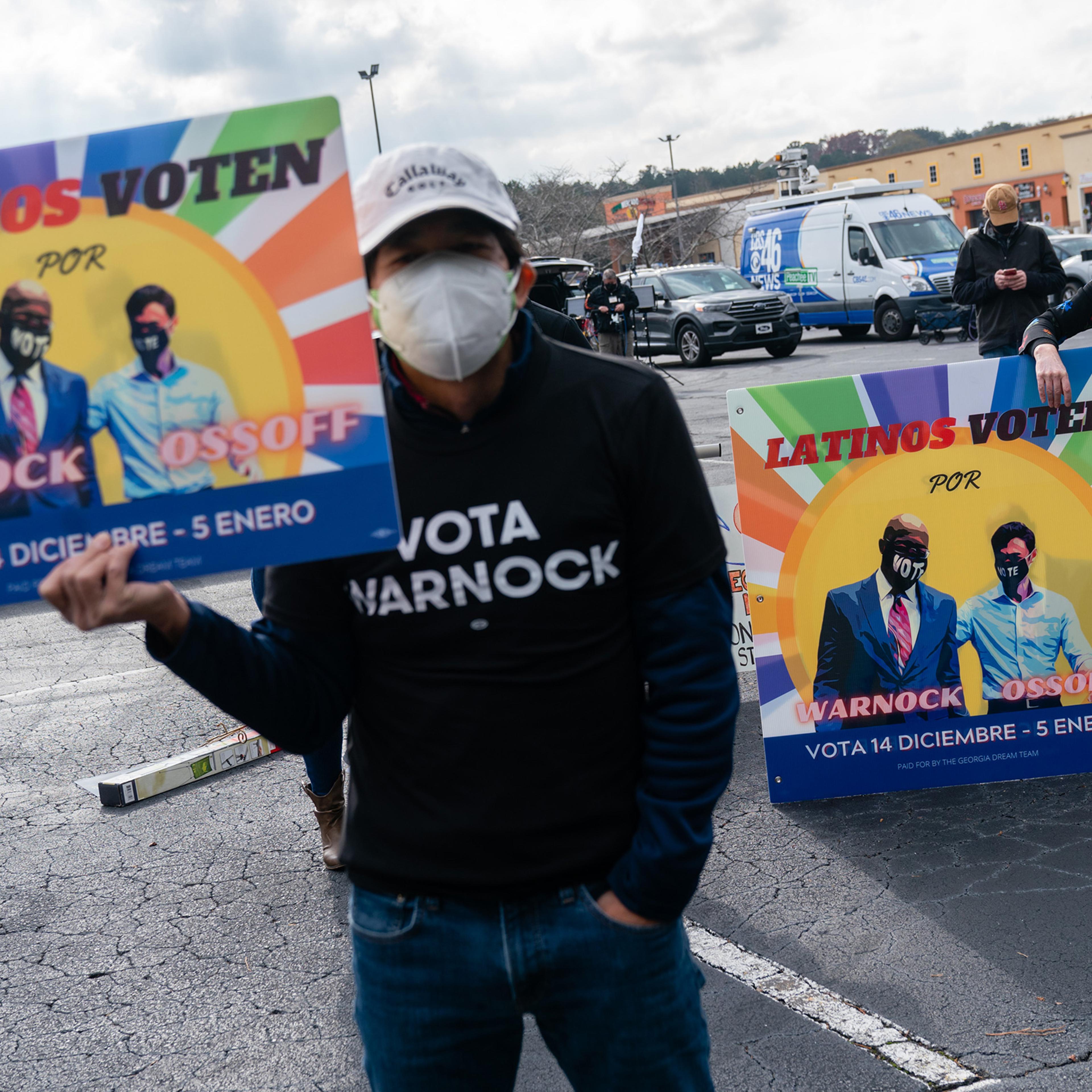 Attendees hold signs during a campaign event for Democratic Senate candidate Jon Ossoff in Lilburn, Georgia, on Dec. 7. R